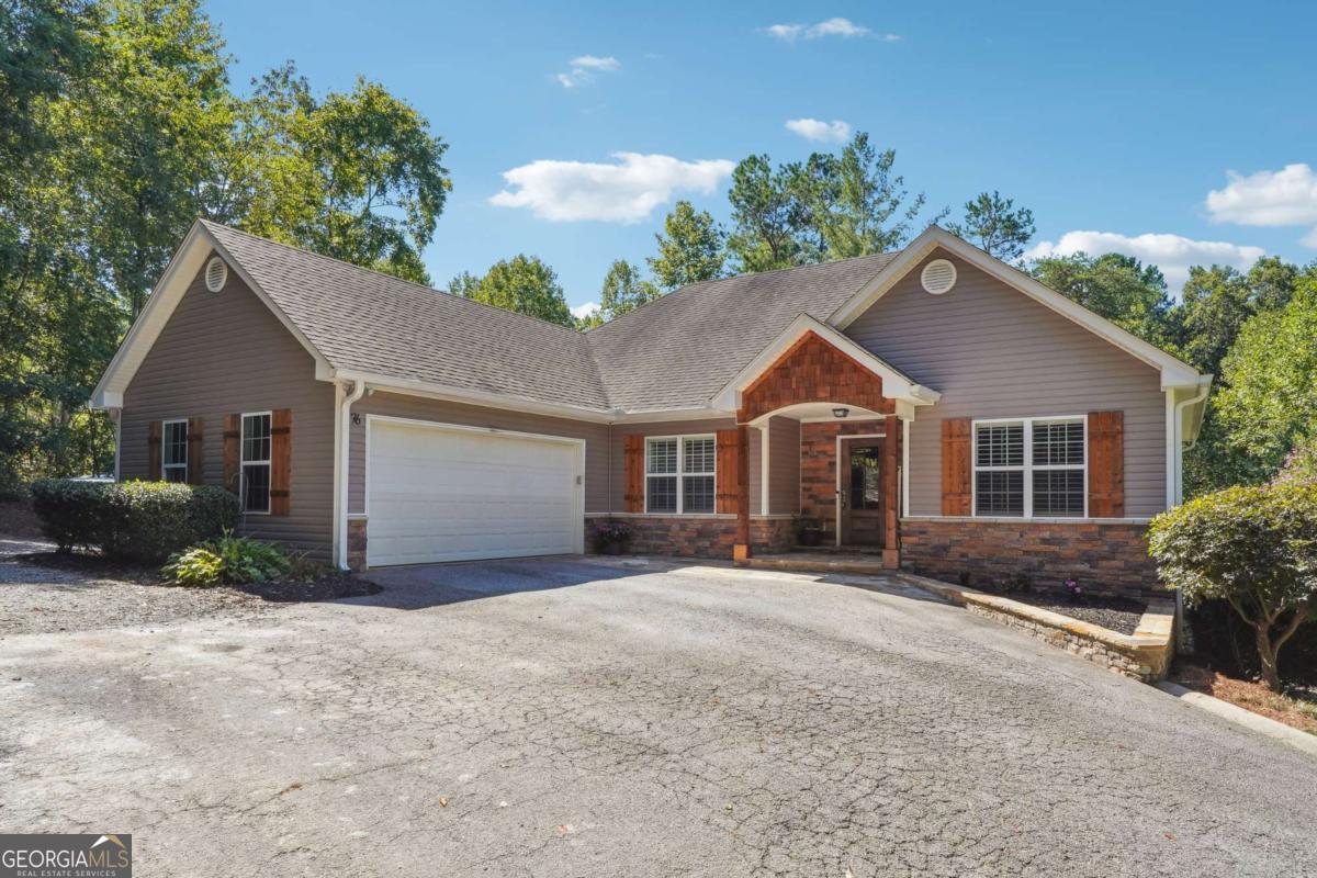 Beautiful ranch-style home on over an acre of private land with NO HOA! Located just minutes from downtown Dawsonville and the North Georgia Premium Outlets, this home offers the perfect blend of comfort and convenience. The main level features an open-concept living area with vaulted ceilings and abundant natural light. The kitchen is equipped with granite countertops, stainless steel appliances, and flows seamlessly into the spacious living and dining areas. The primary suite on main includes double vanities, a separate tub and shower, and a generous walk-in closet. Two additional bedrooms and a full bath complete the main floor-ideal for family or guests. The partially finished basement includes a full bedroom, full bath, and an additional flex space perfect for an office, media room, or gym. Ample storage or potential to finish even more space! Outside, enjoy a newly installed 50x40 shop with private entry and plenty of parking. Don't miss this rare opportunity in a prime location-schedule your showing today!