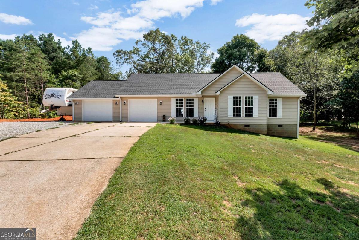 Charming Country Home with Modern Upgrades in a Quiet Subdivision Welcome to this beautifully maintained 3-bedroom, 2-bath home offering the perfect blend of modern updates and peaceful country living. Situated in a quiet subdivision, this immaculate home has been thoughtfully updated throughout and is move-in ready. Inside, you'll find durable and stylish luxury pergo flooring throughout the home, adding a cohesive, low-maintenance touch to every room. The bright and inviting kitchen features new cabinets, granite countertops, and new stainless steel appliances, while both bathrooms have been fully renovated with new cabinetry and modern showers. Additional interior upgrades include crown molding, exposed ceiling beams, and the removal of popcorn ceilings, giving the home a clean, updated feel. This all-electric home also includes a newer roof (approximately 2 years old), a whole-house water filtration systemlocated in the crawlspace, and a propane-powered generator (not a whole-house unit) for added peace of mind. Outside, enjoy the covered back porch, two attached garages, and a 40-foot shipping container for ample storage. There's also a 50-amp RV hookup tied into the septic system-perfect for guests or recreational use. Trailwaves high-speed internet is available for easy connectivity. This home is in excellent condition, extremely clean, and meticulously maintained-a true gem for anyone seeking modern comfort in a quiet, country setting.