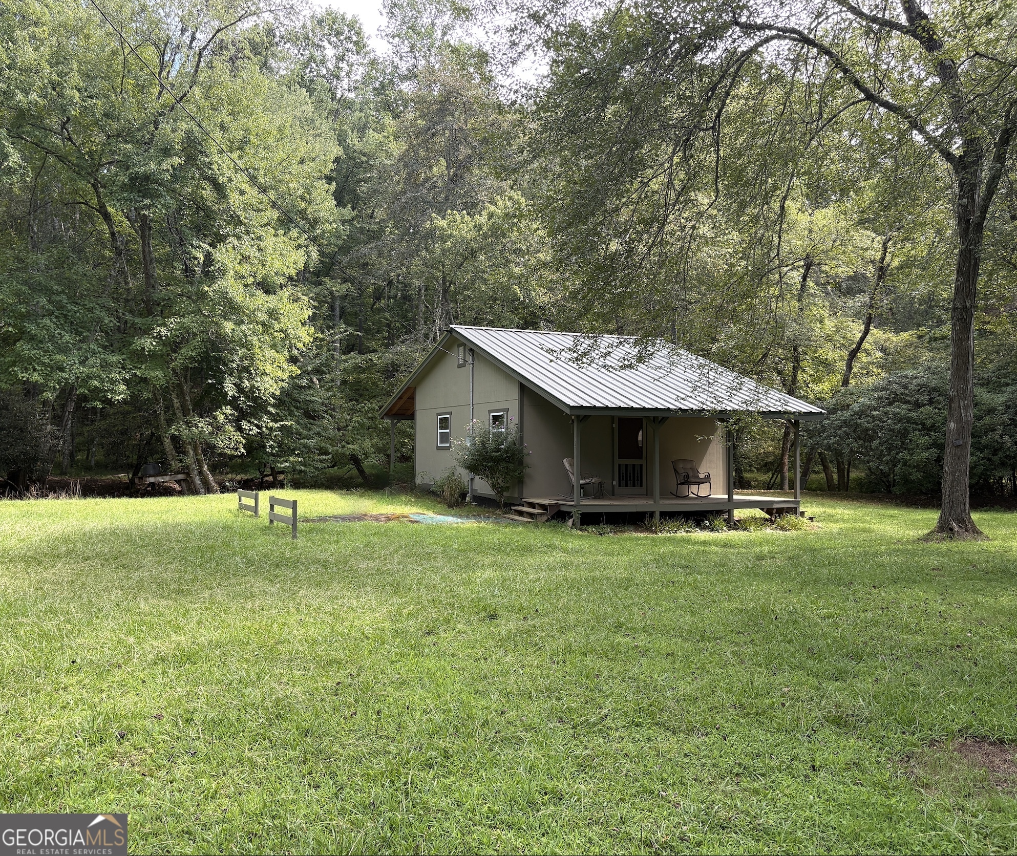 Go back into a simpler time when mountain cabins were quaint, simple, and built for functionality. And this one sits just feet from Wolf Creek with waterfalls and good fishing/play areas. All level usable acreage with an outbuilding and RV storage. Open area for games, fire pit, camp space. No restrictions, STRs are good to go and would be an incredible opportunity. Room to expand as well.