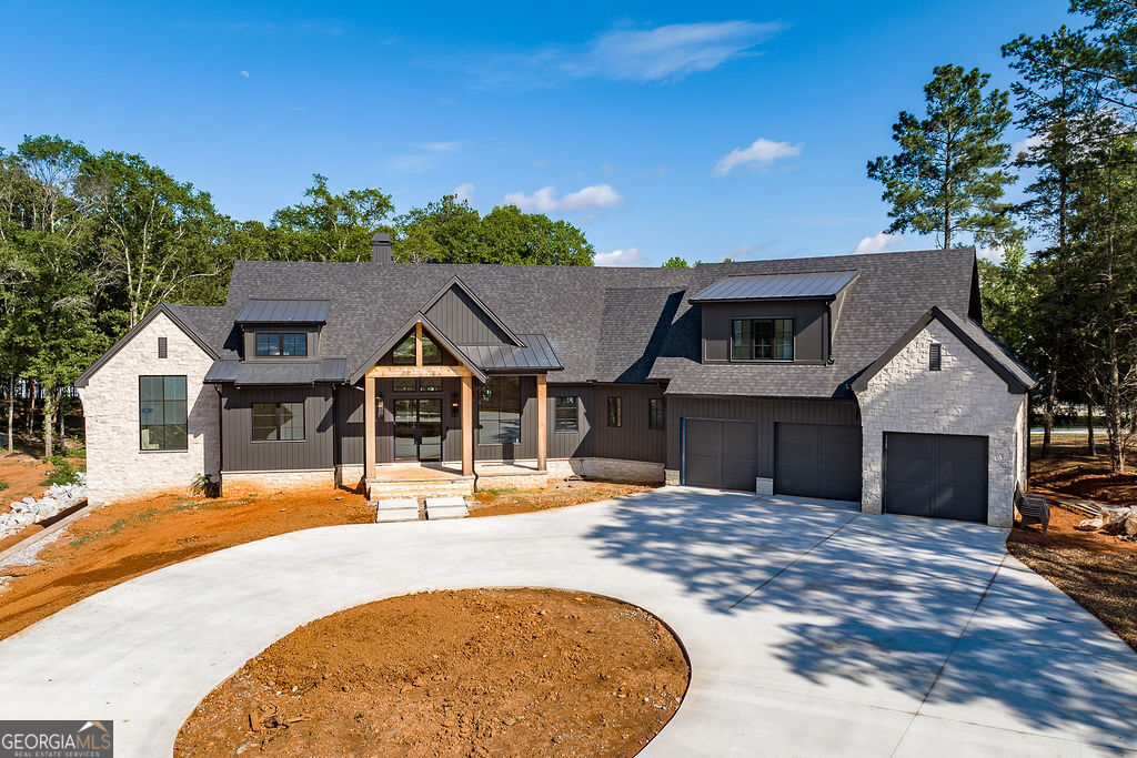 A rare opportunity to be the first to live in this luxury lakefront retreat in The Georgia. Where luxury is in the details and lakefront living reaches new heights, this premier custom home on the shores of Lake Hartwell combines timeless craftsmanship with modern design and is thoughtfully tailored to support a seamless, sophisticated lifestyle. Now in its final stages of construction, it offers a unique chance to enjoy new construction without the wait, while still selecting a few final touches to make it your own. From sunrise coffee to sunset views, this home is designed for how you live, relax, and recharge. Fully custom-built with over 5,000 square feet of high-end design, quality construction, and intentional spaces, the layout supports effortless entertaining, private retreats, and everyday ease. Private bedroom suites, generous gathering areas, and luxurious details throughout make this home truly one of a kind. Step through custom powder-coated steel and glass doors into the show-stopping great room. Vaulted, tongue and groove ceilings and a central gas fireplace anchor the space, while floor-to-ceiling Marvin casement windows in front and Marvin patio doors at the back flood the room with natural light and frame peaceful lake views from the moment you walk in. Wide-plank white oak floors with cork underlay, custom wood ceiling treatments, and artfully selected finishes bring a layered sense of warmth, texture, and dimension to every space. The open-concept kitchen features a massive island, high-end appliance package, and a coveted scullery pantry with prep sink, second dishwasher, and ice maker - the perfect balance of beauty and function. Outside, Brazilian Tigerwood decks span the entire width of the home, designed for exceptional outdoor living with a built-in gas grill hookup, outdoor fireplace, and access from the living room, dining room, and primary suite. A charming awning window off the kitchen connects indoor and outdoor living beautifully. The main-level primary suite features vaulted ceilings, lake views, and direct deck access. Its spa-inspired bath offers an oversized tiled shower, freestanding soaking tub, and double vanities. Large-format ceramic tiles and an expansive picture window enhance the sense of serenity. A massive two-sided walk-in closet completes the suite with both beauty and practicality. Upstairs, a luxurious secondary suite provides a private guest retreat with its own stunning en suite bath. The full, walk-out terrace-level basement includes a large den with a second fireplace and a wet bar - ideal for entertaining and countless hours of fun. A dedicated home office offers inspiration with lake views, while two additional bedrooms and two full baths create private accommodations. A flexible bonus space is ready for your personal touch - perfect for a home theater, game room, or even a golf simulator. Need more space? Add a closet and easily convert it into a fifth bedroom, an option left for you to decide. Function hasn't been overlooked: enjoy four separate HVAC units, a powder room on the main level, laundry rooms on both floors, and a single tankless water heater with full home circulation for instant hot water. Even the outdoor faucets offer hot and cold water in both the front and back. A large mechanical room includes centralized valves in a functional unfinished space, and smart home technology manages lighting, climate, and irrigation. There's plenty of storage for lake gear and outdoor essentials. The property is situated on 1.17 acres, plus nearly an acre of additional Corps of Engineers land, offering extended privacy and buffer to the water. Full utilities run to the dock, ensuring maximum enjoyment of lakeside living. Convenient to downtown Hartwell, Hartwell Marina, local dining, shopping, and with easy access to Atlanta, Athens, and Greenville, 123 Carlota Way invites you to make your mark, settle in, and live the lake life of your dreams.