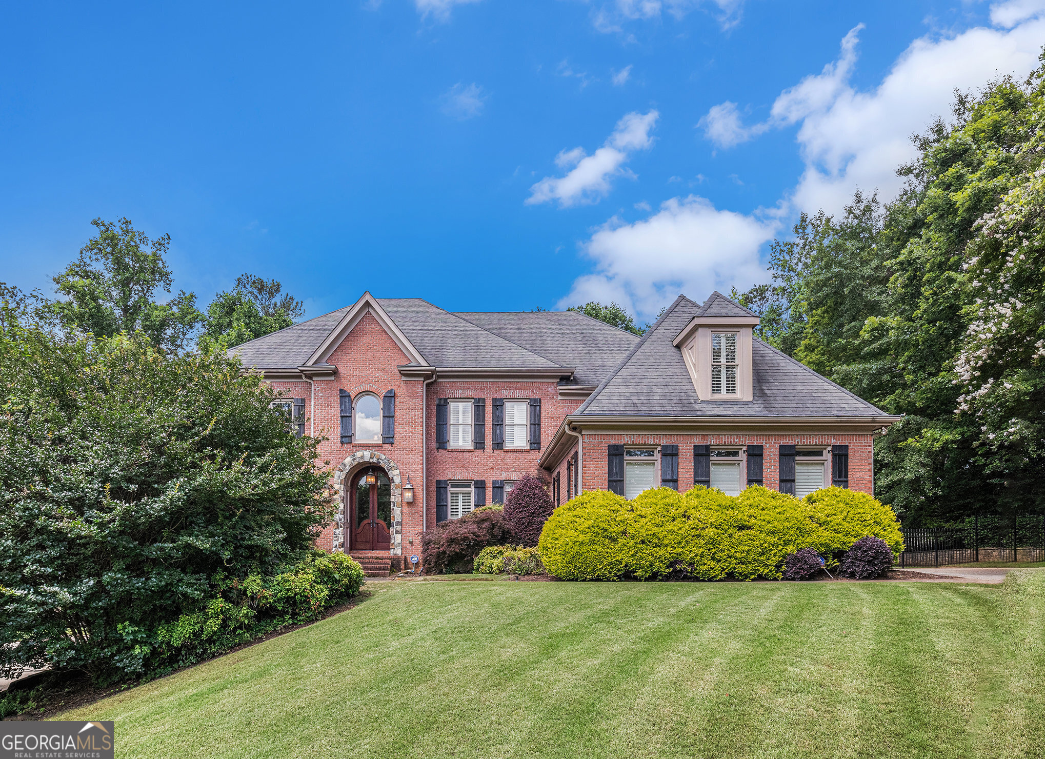 This stunning, movein ready custom estate sits at the end of a culdesac on a full acre bordering the Lakeside Golf Course at the Golf Club of Georgia, boasting professionally landscaped grounds that include a saltwater pool and spa. Inside, the home is a chef's dream with a fully upgraded gourmet kitchen featuring premium Wolf and SubZero appliances, large granite island with prep sink, and a butler's pantry with refrigerated drawers and beverage cooler. Plantation shutters, custom stained cabinetry, integrated audio, and iPod dock elevate the interior throughout. The terrace level impresses with a full bar, game room, media room, guest suite, and retractable awning over a lowlevel deck-perfect for both entertaining and everyday living. The luxurious owner's retreat features a sitting area and spastyle ensuite, while the property's prime location offers toprated schools, premier neighborhood amenities, and easy access to Avalon and downtown Atlanta under 30 minutes away.