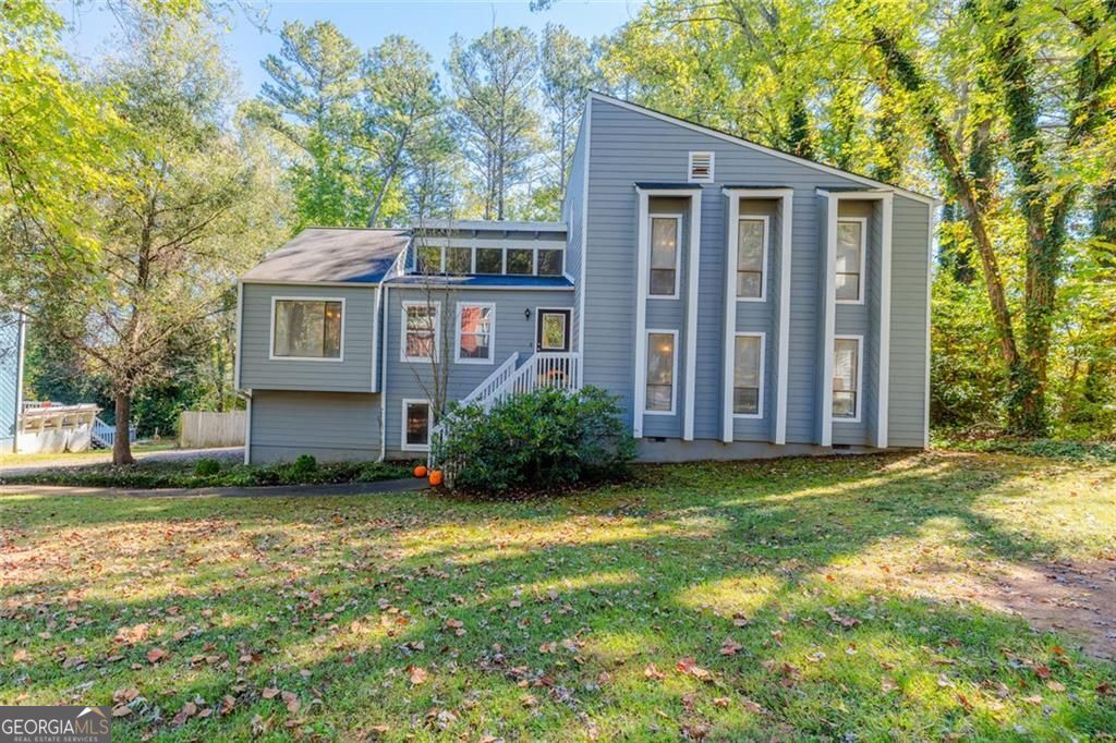 You will fall in love with this beautifully updated contemporary home sited in a walkable, convenient East Cobb neighborhood. The interior boasts stunning trim work and architectural design including a soaring vaulted family room with natural wood beams and a cozy fireplace for relaxing on cool fall nights. The family room opens to the dining room area leading to the updated kitchen with stainless steel appliances, breakfast bar, sleek granite countertops and tiled backsplash. Lush hardwood floors carry throughout much of the home. On the upper level you find the spacious owner's suite with updated ensuite bath. Two additional spacious bedrooms and full bath are found on the upper level. Transcending to the lower level provides a fabulous space for teen hang out or private guest quarters, offering a spacious gathering room and very large bedroom another ensuite bath. Outdoor entertaining is a breeze with two large decks and flat backyard with wooded perimeter for added privacy. The home offers a 2-car garage and lots of storage space! The property is located in a prime Marietta neighborhood near excellent schools, dining, parks, shopping and more!