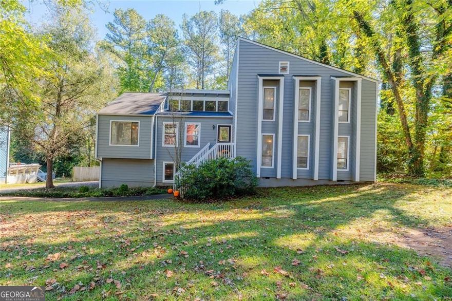You will fall in love with this beautifully updated contemporary home sited in a walkable, convenient East Cobb neighborhood. The interior boasts stunning trim work and architectural design including a soaring vaulted family room with natural wood beams and a cozy fireplace for relaxing on cool fall nights. The family room opens to the dining room area leading to the updated kitchen with stainless steel appliances, breakfast bar, sleek granite countertops and tiled backsplash. Lush hardwood floors carry throughout much of the home. On the upper level you find the spacious owner's suite with updated ensuite bath. Two additional spacious bedrooms and full bath are found on the upper level. Transcending to the lower level provides a fabulous space for teen hang out or private guest quarters, offering a spacious gathering room and very large bedroom another ensuite bath. Outdoor entertaining is a breeze with two large decks and flat backyard with wooded perimeter for added privacy. The home offers a 2-car garage and lots of storage space! The property is located in a prime Marietta neighborhood near excellent schools, dining, parks, shopping and more!