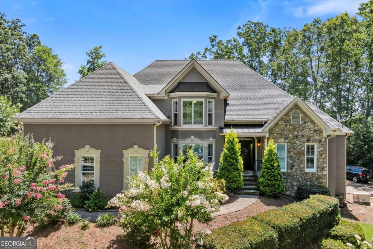 Welcome to 3400 Williams Road - a beautifully updated, private 1-acre estate in the heart of East Cobb, perfectly situated in the top-rated Pope High School district. This exceptional home combines timeless design with thoughtful modern updates. The exterior features a classic hard-coat stucco and stone facade, complemented by professionally landscaped grounds. Since 2021, the current owner has completed a full renovation of the kitchen, all bathrooms, and laundry room-and even installed new double-paned windows throughout for added efficiency and comfort. Step into the grand two-story foyer, flowing seamlessly into a dramatic living room filled with natural light-perfect for gatherings or quiet relaxation. The main-level primary suite is a private retreat with tray ceilings and a spa-like bath that includes double vanities, a soaking tub, and a separate walk-in shower. The elegant half bath, designed with Serena & Lily flair, adds a stylish touch for guests. The expansive eat-in kitchen is both functional and beautiful, with stainless steel appliances, an oversized center island, and generous cabinetry. The adjoining keeping room features a floor-to-ceiling stone fireplace that anchors the space with warmth and charm. Upstairs are three generously sized bedrooms and two and a half full bathrooms (one with a convenient Jack-and-Jill layout), all with excellent closet space. The fully finished terrace level offers versatility with a private bedroom suite (including a renovated full bath and walk-in closet), a home theater, office, and abundant storage. There is also private garage access on this level with a private second driveway-ideal for guests or multigenerational living. Step outside to an entertainer's dream: Brazilian hardwood deck overlooking a beautifully lawn, complete with a newly added hot tub-perfect for both weekend entertaining and quiet evenings under the stars. One of the most unique features of this home is its six-car garage, ideal for car collectors, boat owners, or anyone in need of secure storage. Additional features include a whole-house generator, newer mechanical systems, and a detached shed currently being used as a dance studio-offering endless possibilities. This is a rare opportunity to own a truly move-in-ready estate in one of East Cobb's most desirable areas. Come experience 3400 Williams Road-you won't be disappointed!