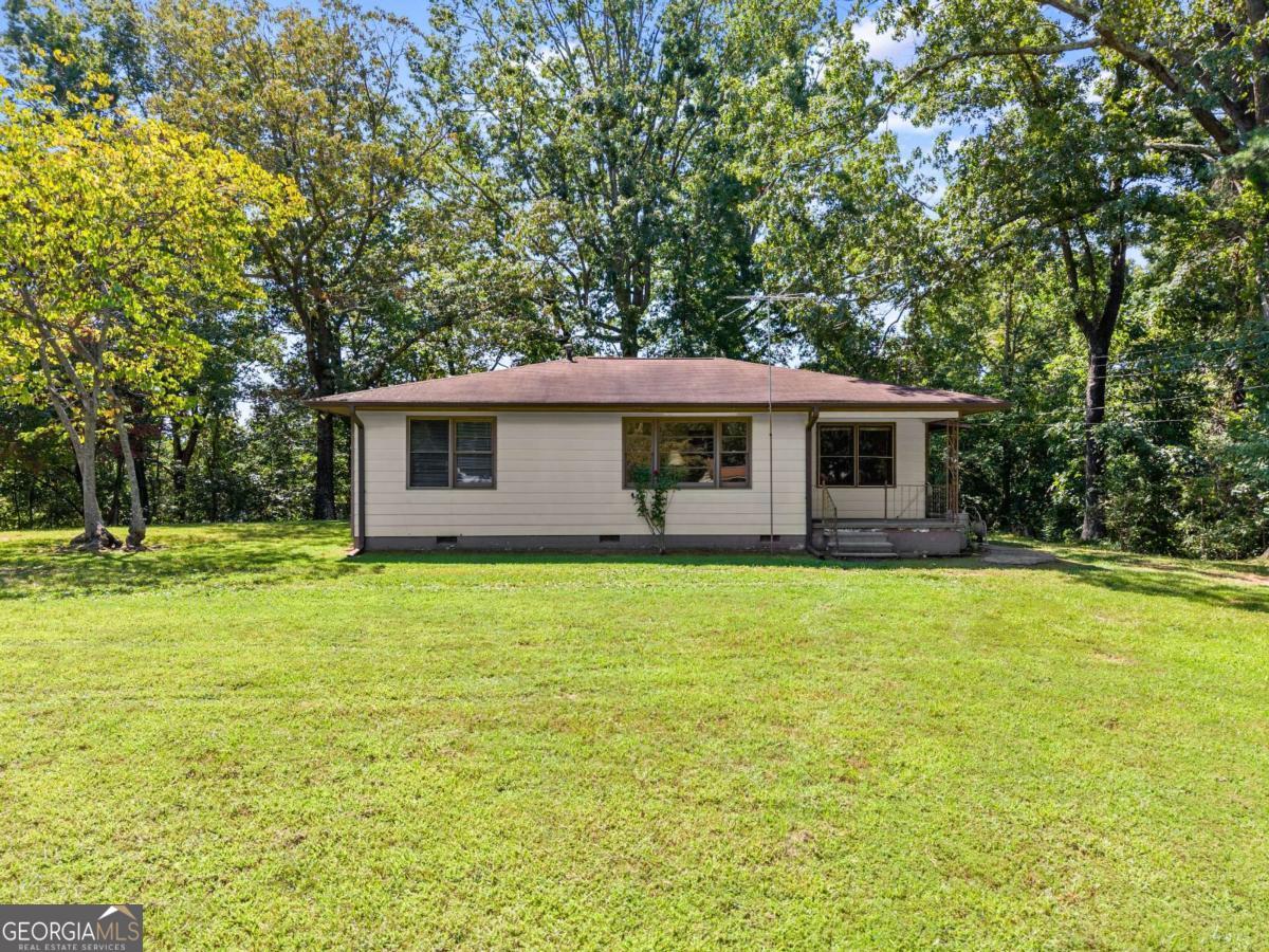 Discover peaceful country living on this 2.42-acre Hall County property, featuring a cozy 2-bedroom, 1-bath ranch-style home. Surrounded by mature trees and open yard space, this home offers the perfect blend of privacy and nature. Inside, you'll find hardwood floors, a spacious living room, and a vintage-style kitchen with abundant cabinet storage. The full bath includes a double vanity and tub/shower combo, making it practical for everyday living. Outside, enjoy plenty of usable land. Ideal for gardening, small animals, or simply relaxing in your own private retreat. With endless potential for updates or expansion, this property is a rare find for first-time buyers, investors, or anyone seeking quiet acreage in North Georgia.
