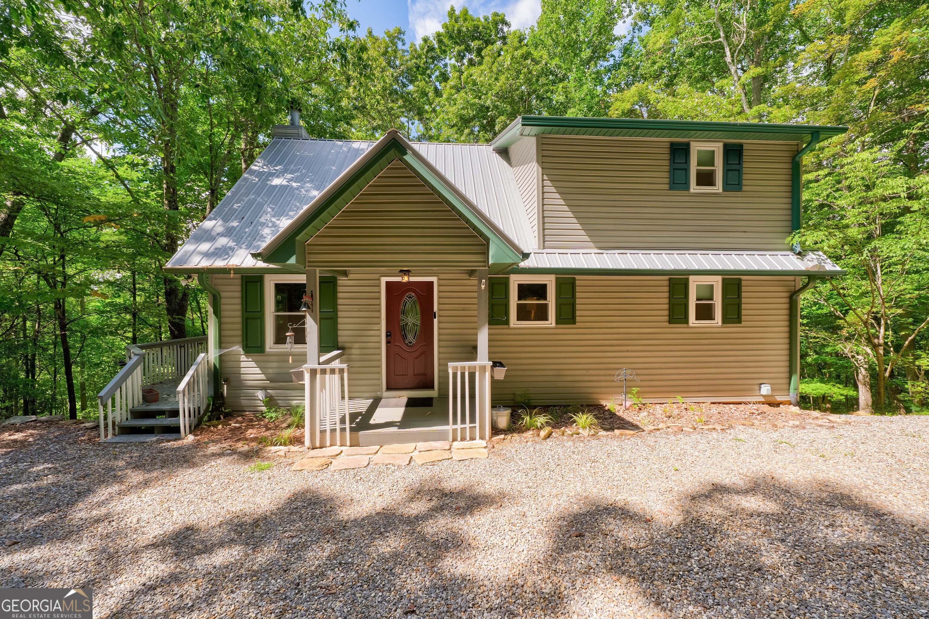 Welcome to 708 Wilson Mountain, Blairsville - Your Serene Mountain Retreat! Tucked into a quiet, leafy enclave of elegant mountain homes, this beautifully remodeled cabin offers both privacy and community charm. Upgrades include premium vinyl siding, a durable metal roof, and stunning hardwood flooring in the expansive great room, highlighted by cathedral ceilings and a welcoming stone fireplace with gas logs-ideal for cozy evenings with loved ones. The bright, open layout features a generous dining area and living space, perfect for hosting friends and family. Both bathrooms have been tastefully updated with new tile floors and walls, complemented by stylish vanities. The spacious master suite shines with its own hardwood floors, roomy walk-in closet, and private bathroom retreat. Step outside to the inviting covered screened porch-picture sipping your morning coffee here as you admire filtered mountain views with just a bit of tree trimming. The finished walk-out basement adds valuable living space, featuring a full bedroom with tile flooring, a versatile family/den room also with tile, and a large mechanical/laundry/workshop area. With a practical layout, this home blends enduring quality with laid-back mountain living. 708 Wilson Mountain is the perfect blend of seclusion, thoughtful upgrades, and turn-key mountain comfort-ready to welcome you home!
