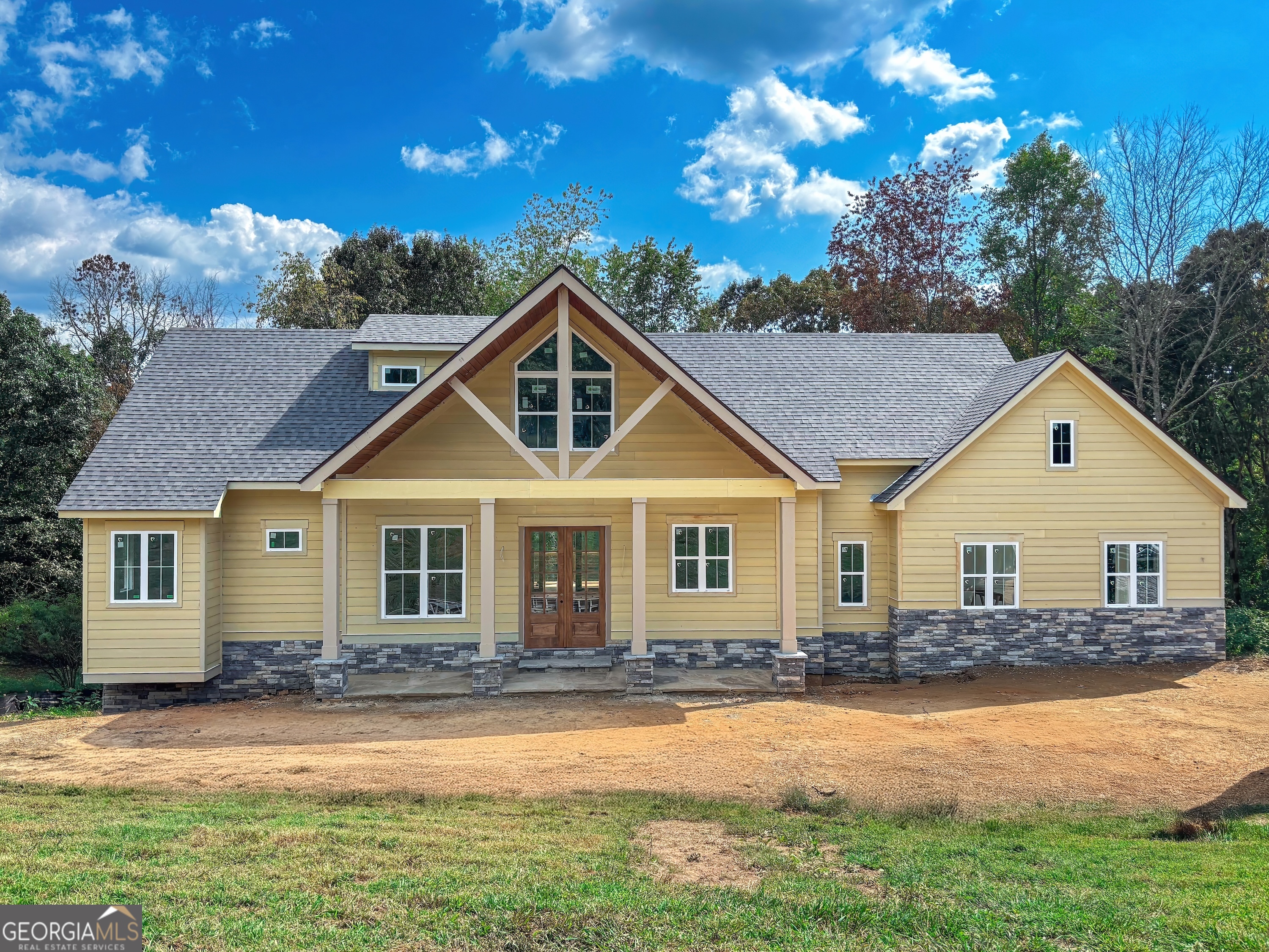 Currently under construction by TS Family Homes, this 3BR / 3.5BA, 3,242-square-foot modern craftsman combines timeless curb appeal with modern functionality in one of North Georgia's most sought-after gated golf communities. The home offers 1,505 square feet on the main level, 513 square feet upstairs, and an additional 1,224 square feet in the finished basement, providing flexible space for family, guests, or hobbies. The open-concept main level is anchored by a stunning stone fireplace and a gourmet kitchen that makes entertaining effortless. There is no such thing as "builder grade" with TS Family Homes; every detail is elevated. The kitchen features custom soft-close cabinetry, granite countertops, high-end stainless steel appliances, and a large island perfect for gatherings. Bathrooms are finished with granite countertops and custom tile showers, with tile extending all the way to the 10-foot ceilings for a truly luxurious feel. Even the interior solid-wood doors are 8 feet high, enhancing the home's sense of space. Additional features include a laundry room, 2-car garage, and covered porches to enjoy the peaceful surroundings. Craftsman-style architecture, distinctive stone accents, and quality finishes inside and out create a welcoming, enduring design. The Owen Glen community offers resort-style amenities, including a clubhouse, swimming pool, tennis and pickleball courts, a fitness center, walking trails, and the acclaimed Old Union Golf Course with a Pro Shop. Located just minutes from downtown Blairsville, Lake Nottely, and the Chattahoochee National Forest, residents enjoy the perfect blend of recreation, relaxation, and community. Don't miss this rare opportunity to own a brand-new modern craftsman in an amenity-rich, gated setting. Secure your place in Owen Glen today and experience exceptional construction quality paired with timeless design.