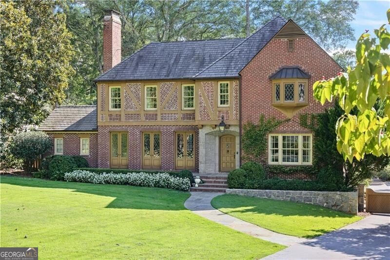 Spectacular renovation and expansion by Architect Stan Dixon in Haynes Manor! This impressive home combines super high quality with thoughtful design, featuring impeccable craftsmanship and elegant spaces ideal for both living and entertaining. The property greets you with a large front lawn leading to a pretty bluestone patio and grand entry. Upon entering, the spacious foyer opens to a formal dining room with beautiful built-in china cabinets, and an oversized fireside living room with wrought-iron, leaded glass French doors that open to the front patio. The bright kitchen is designed with marble countertops, Wolf/SubZero appliances, a central island with a prep sink, and a scullery complete with a Miele coffee station and extra storage. A wet bar with an antique glass backsplash, wine fridge, and icemaker is conveniently located between the kitchen and dining room, making it perfect for hosting gatherings. The family room extends to an incredible covered back porch equipped with a large granite fireplace, built-in Wolf grill, fridge, and ample space for seating and dining. Stepping into the flat, walk-out backyard, you'll find a bluestone patio, a heated saltwater pool, and beautifully landscaped grounds including a wide grassy playfield, creating a serene outdoor retreat. The main level also includes the primary suite, which boasts a vaulted ceiling, a balcony overlooking the backyard, and a spa-like bath with dual vanities, a soaking tub, shower, and dual walk-in closets. A private guest suite with French doors opening to the back porch ensures privacy and comfort for visitors. This level also includes a laundry room and two half baths-one formal and one conveniently located for pool access. A staircase with a beautiful wrought iron railing leads to the second floor which includes three large en suite bedrooms, a second laundry room, and a nice flex space with built-in seating and bookshelves. The bedrooms are all ample size with additional living space, window seats and one with an incredible screened-in sleeping porch overlooking the private backyard. The bathrooms have been perfectly designed for functionality and pleasing details such as casement windows, marble finishes and custom Dixon-designed cabinetry. The daylight terrace level, accessed by another lovely wrought iron staircase and a wall of windows, offers additional amenities, including a top-of-the-line gym, a spacious recreation room, a separate den/media room, and another half bath. A sizable mudroom connects to the three-car garage, adding both functionality and storage. Additional features include a slate roof, generator, well water for the pool and irrigation system, geothermal HVAC systems, landscape lighting and gated driveway. This home seamlessly blends timeless architectural charm with modern luxury, offering a perfect setting for family living and entertaining in one of Atlanta's most desirable neighborhoods. Conveniently located and a short stroll to the Beltline, shopping and dining.
