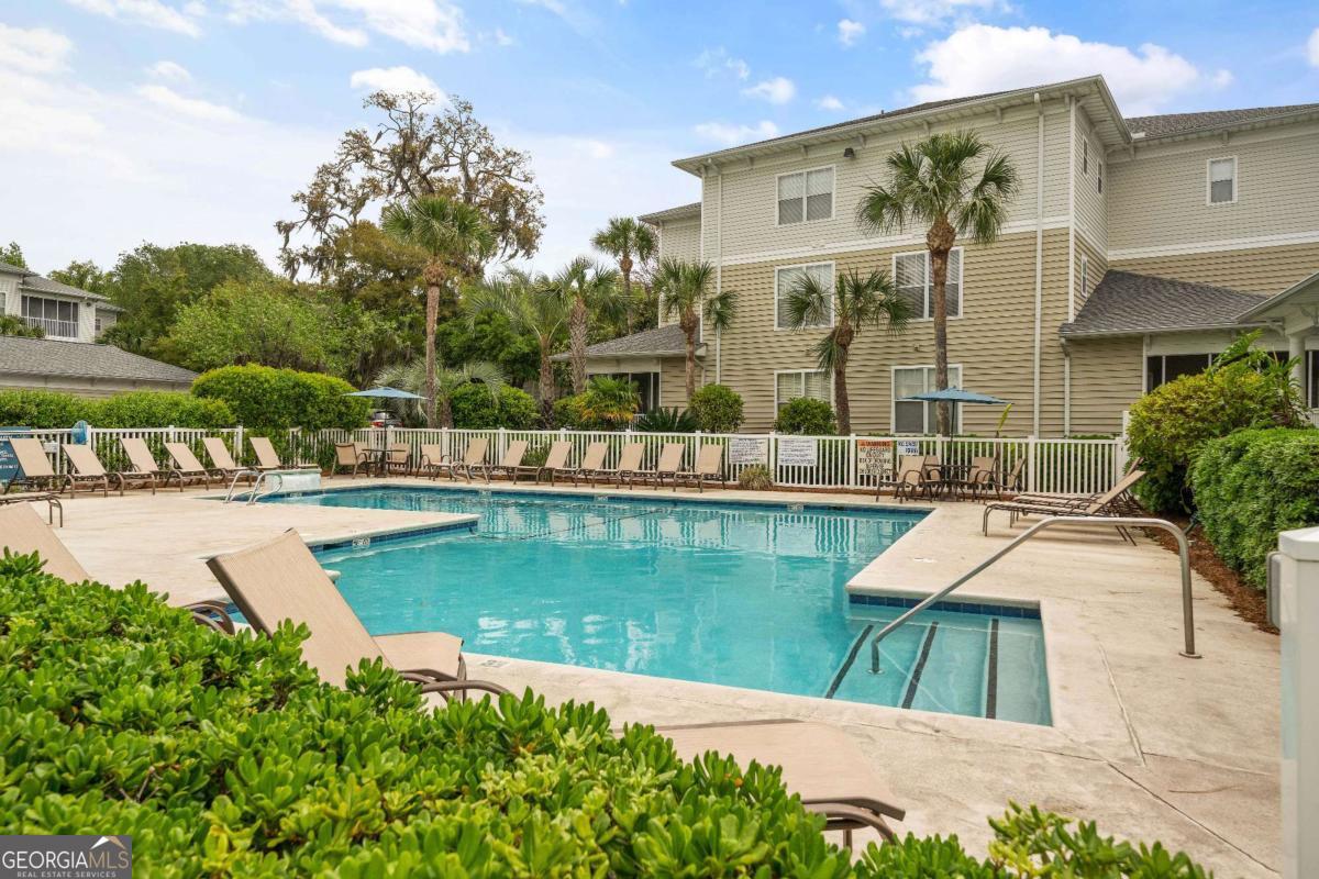 This furnished two-bedroom, two-bath condo in the sought-after Barnes Plantation gated community comes with the rare offering of a garage that's perfect for your car, golf cart, bikes & beach gear. The included garage, which is located right next to the building, adds convenience and functionality with built-in cabinets for organizing smaller items. The open design features a bright kitchen with a breakfast bar overlooking the living room, as well as the dining area. Both the primary suite and guest bedroom include spacious walk-in closets, providing ample storage. The screened porch is a perfect spot to enjoy morning coffee, dine alfresco, or simply relax. A handy storage closet on the porch keeps essentials within easy reach. The condo is also just steps from the community pool, making it easy to enjoy the amenities of this well-maintained complex. Conveniently located in the mid-south area of St. Simons Island, this condo is within walking distance of some of the island's best restaurants and shops! Don't miss this rare opportunity to own a turnkey condo with a garage in one of St. Simons Island's most desirable locations!