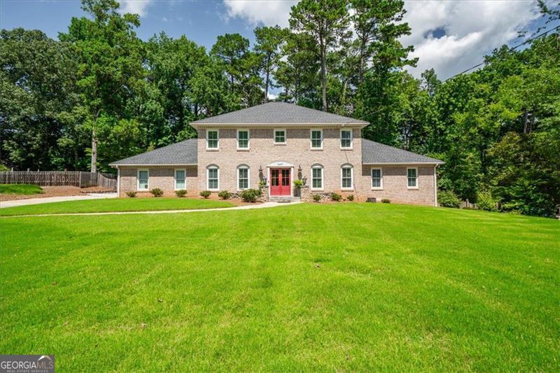 Four sided Brick Traditional with both charm and modern updates in The Forest at Smoke Rise. This stunning 5-bedroom, 4.5-bath with primary bedroom on main features, gleaming hardwood floors, newer windows and doors, and an open-concept layout ideal for entertaining. The renovated kitchen features quartz countertops, stainless steel appliances, and ample cabinetry, seamlessly flowing into the family room with a cozy fireplace and views of the expansive, fenced backyard complete with a stone patio, basketball court, and room to garden or play. The main-level primary suite boasts an oversized spa-like shower and walk in closet. Upstairs you have 4 spacious bedrooms with large closets, hardwood floors and lots of light! The fully finished basement includes a kitchenette, full bath, home theater, large recreation room, gym, a walk out to the side yard and abundant storage- perfect for guests or multi-generational living. All situated on a large, flat half-acre lot that provides exceptional privacy and serenity in this coveted neighborhood.