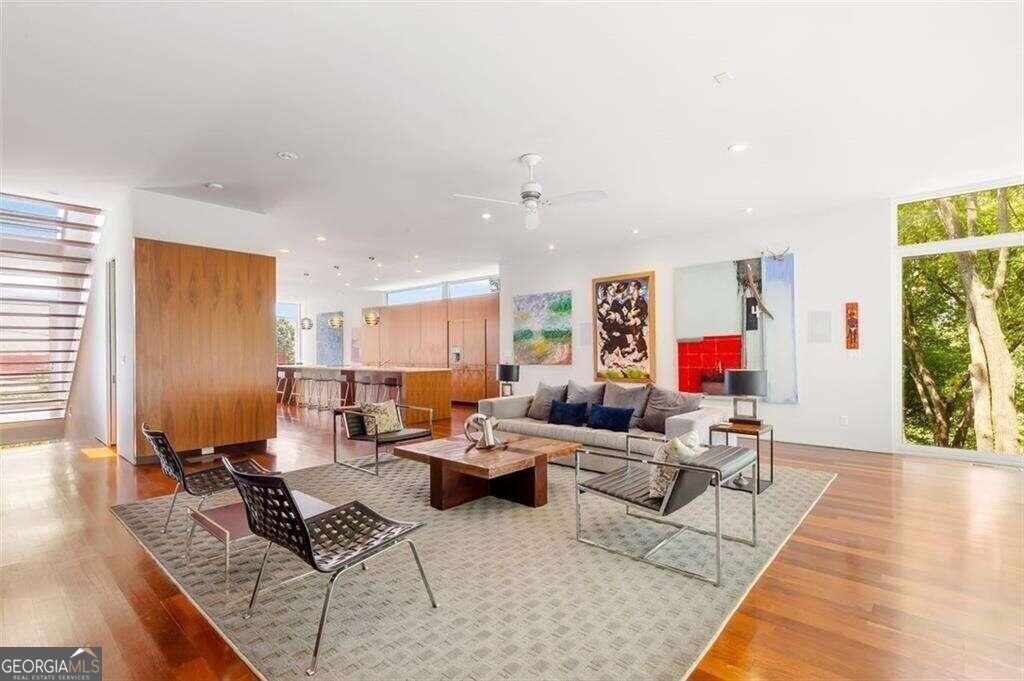 Nestled in the heart of Old Fourth Ward, this custom-built modern marvel was thoughtfully imagined by renowned architect, Scott West. Overflowing with architectural intrigue, this is the largest-ever modern single-family home built in O4W and is one of the few exclusive residences providing direct access to the Freedom Park Trail, peacefully connecting this modern oasis with the Beltline just 2 blocks away. This trophy home is the envy of the neighborhood with a rare 3-car garage + storage, coveted off-street parking and spacious backyard retreat with room for an in-ground pool. Sleek modern detailing starts from the outside in with the awe-inspiring exterior glass curtain wall gracefully integrated with standing metal seam siding and Brazilian Walnut accents. Luxury is truly in the details across the four distinct levels of living space plus a dramatic rooftop terrace with skyline and treetop vistas. Upon entry you are greeted by an iconic floating stairwell drawing you up to the main living level anchored by the stunning custom kitchen. Dramatic hand-crafted cabinetry conceals hidden appliances with book-matched walnut panels. Oil-Finished Brazilian Walnut flooring seamlessly connects the kitchen with the spacious living room wired for a home theater. The dining room is truly designed with entertaining in mind, with in-ceiling speakers. Massive floor-to-ceiling windows flood these spaces with light and a gracious rear deck provides ample outdoor living space with hidden stairs leading to the yard and beyond. Ascend upstairs to find the private owner's suite offering a zen-like retreat from the day-to-day with an oversized jacuzzi tub, massive steam/shower combo, two walk-in closets, sitting area and skyline views from a private balcony. This level also includes 2 additional bedrooms, a full bath, laundry room and even a loft. Up one more level to the 700sqft private rooftop deck outfitted with plumbing for a wet bar...if you can't tell entertainment is at the core of this home's design. Space is no concern with the entry level offering two foyers, 2 additional bedrooms, a full-bath and access to the garage. Not to be outdone the bottom floor is home to the day-light basement flex space offering you an abundance of opportunities. Truly an Atlanta home unlike any other from the custom designed interior with details abound and direct access to the most exciting Intown neighborhood from your doorstep. Whether morning runs to Piedmont Park, midday bike rides to Krog Street Market, or evening strolls to dinner in nearby Inman Park, this location and truly unique modern residence offers unparalleled access to all Intown living affords.