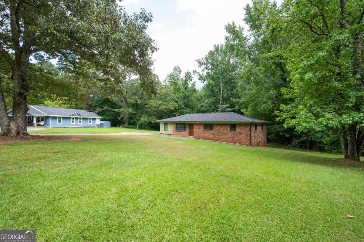 Welcome to the heart of South Fulton! This charming three-bedroom, single-floor residence offers an updated kitchen and bath, complemented by gleaming hardwood floors that flow throughout the home. The converted garage provides a spacious laundry room and versatile bonus space perfect for a home office, play area, or additional living quarters. Relax in the cozy den after a long day, or enjoy the gentle breeze on the inviting deck. With its solid four-sided brick construction and expansive lot of over 3/4 of an acre, this home is a true gem. Ideal for first-time home buyers or families seeking a property with no HOA, and minutes from everything you need. Enjoy the convenience of being close to the airport and bustling Atlanta, with Camp Creek Marketplace just a quick seven-minute drive away. Whether you're starting a new chapter or down sizing, this home offers good bones and endless possibilities on its generous land. Don't miss out-make your appointment today and discover why this is the perfect place to call home!