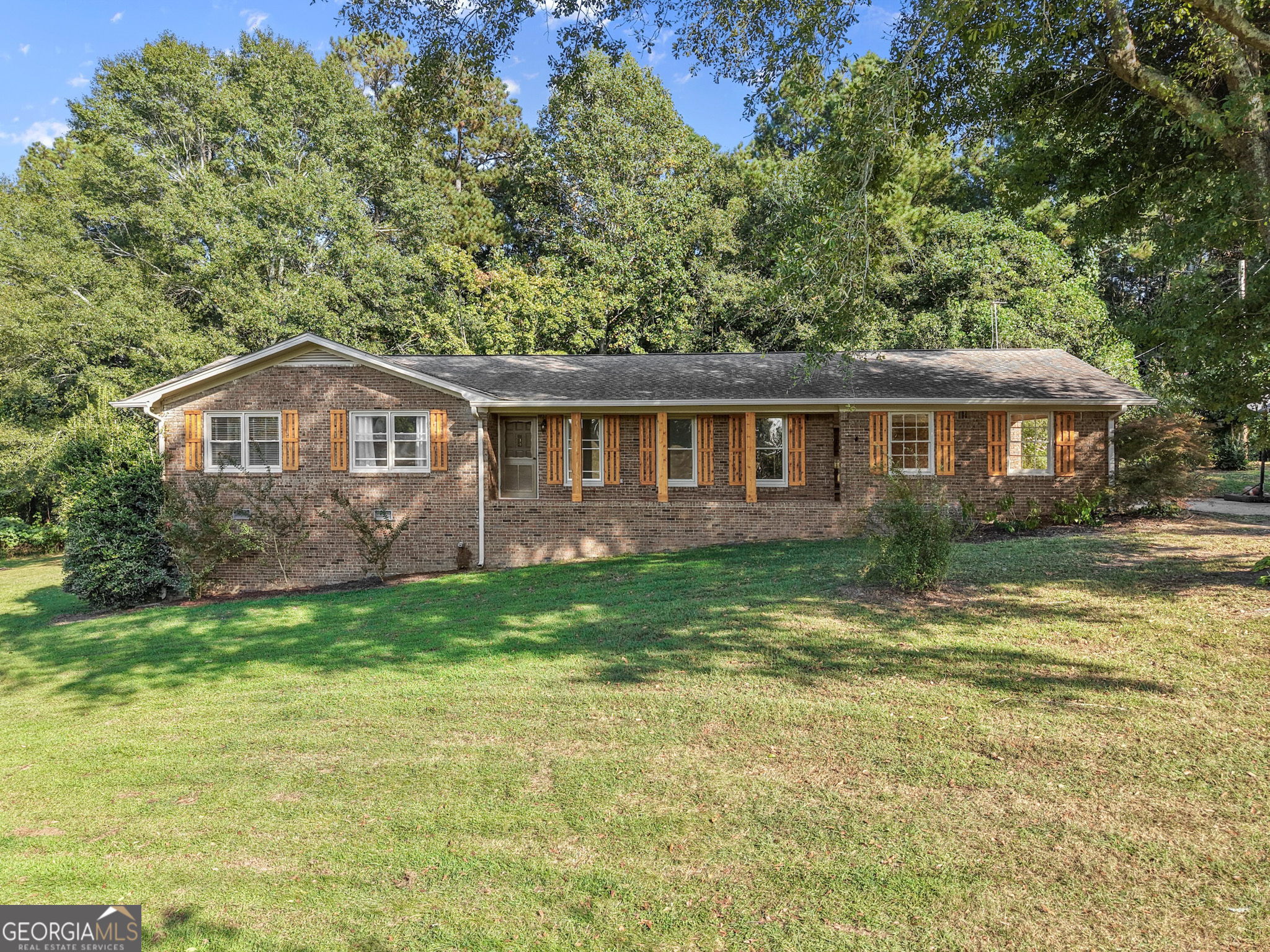 Charming brick and wood-sided ranch with front porch on 1.71 acres. Featuring 3 bedrooms, 3 full baths, and a half-finished basement with a boat door. Enjoy plenty of parking with a 2-car carport, RV parking, and a pole barn. Inside, the family room boasts a masonry fireplace, with additional living space in the den and an office/bonus room. The fully equipped kitchen offers granite countertops, while the remodeled guest bath showcases a quartz vanity. Durable LVP flooring runs throughout most of the home, with carpet in the bedrooms for comfort. Great Value! Great location! Near Gainesville and I985. NOTE:Property is currently served by well water, with public water available for hookup if desired.