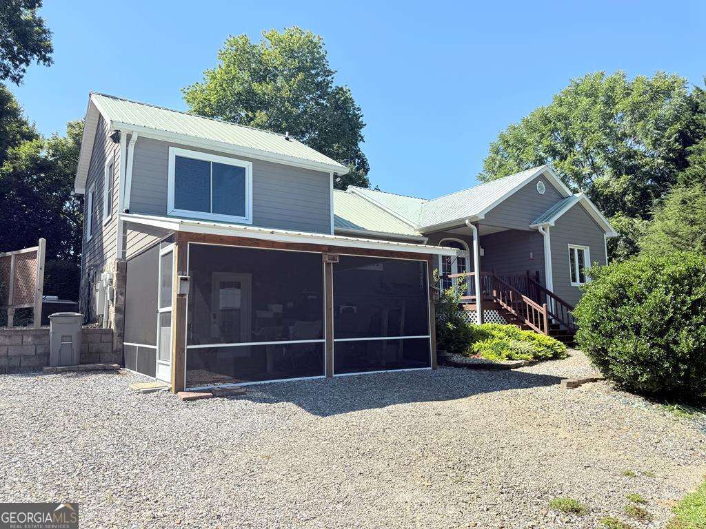 Perched upon a serene hillside, this spacious 2-bedroom, 2.5-bath home offers the perfect blend of comfort, elegance, and mountain charm. Designed to maximize natural light and scenery, the home features a large living room with a cozy gas fireplace, a bright sunroom with mountain view potential, and a separate dining room surrounded by windows-perfect for entertaining or simply enjoying the peaceful setting. The updated kitchen is both stylish and functional, showcasing leathered granite countertops and stainless steel appliances. Two expansive primary en suites provide privacy and comfort, making the home ideal for hosting guests or multi-generational living. Main primary bedroom provides a 10x12 walk in closet designed for an abundance of clothing and storage space. Downstairs, a basement workshop with a walk-out screened porch adds versatility and charm. Outdoor living is unmatched here with multiple decks, a stone fire pit for roasting marshmallows, and a detached garage with two covered sides. Additional features include a Generac backup system, ensuring peace of mind year-round. Whether you're seeking a full-time residence or a mountain getaway, this home offers the perfect retreat to relax, unwind, and soak in the beauty of the Blue Ridge Mountains.