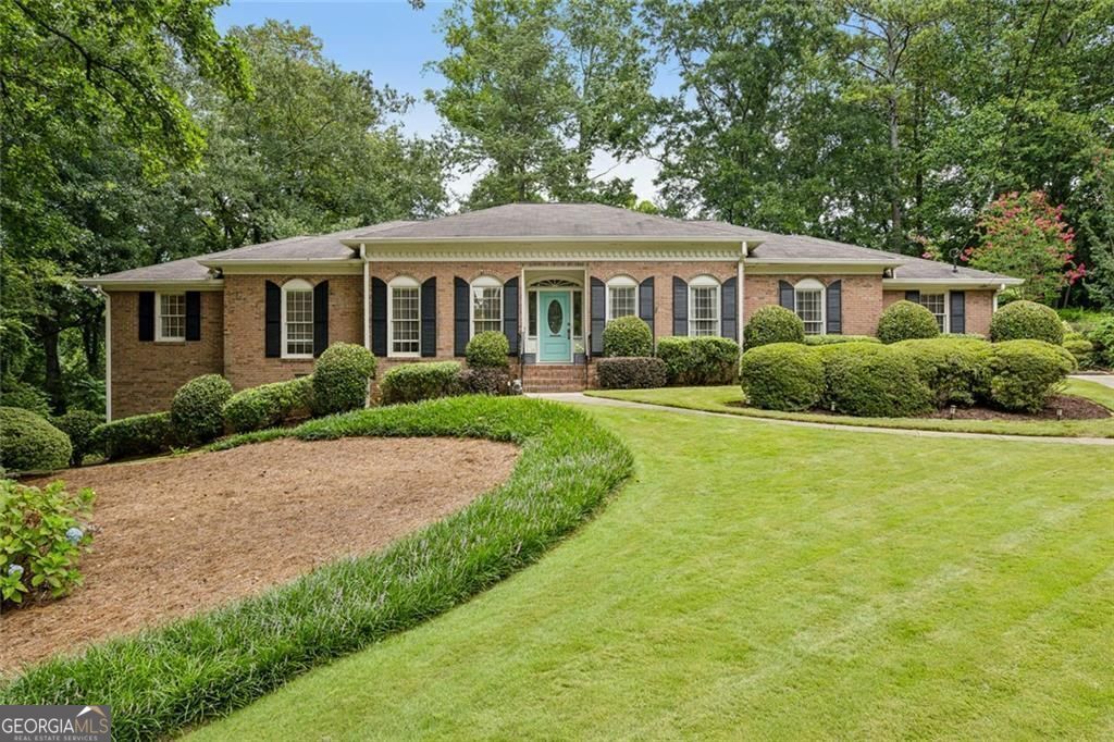 Experience the Best of Classic Brookhaven Living at 3591 Wood Valley Court. This impeccably renovated ranch offers the perfect balance of privacy and convenience, nestled on a quiet street near the intersection of Johnson Ferry & Ashford Dunwoody. Thoughtfully designed for modern living, it combines custom craftsmanship with the flexibility needed for today's lifestyle. The stunning chef's kitchen features custom cabinetry, limestone countertops, stainless steel appliances, and a charming breakfast area-all flowing seamlessly into a warm and inviting fireside den. Gleaming hardwood floors run throughout the home, adding timeless elegance. A gracious formal living room and separate dining room provide additional welcoming spaces for entertaining and relaxing. The convenient laundry/mudroom is equipped with built-in cubbies, abundant storage, and direct access to the attached two-car garage. The primary suite includes two closets PLUS a custom shoe closet and a beautifully renovated, spa-inspired bathroom. Three additional bedrooms on the main level feature double closets with shelving systems, and they share a beautifully updated full bath. Step outside just off the kitchen to unwind on the three-season porch or the sunny deck, both overlooking the serene and private fenced 0.8-acre lot. The finished terrace level offers an additional 400+ sf flexible space with natural light and a private exterior entrance-ideal for a home office, gym, or studio. With optional swim and tennis memberships available at the highly sought-after Brittany Club or Hampton Hall, 3591 Wood Valley Court is Brookhaven living at its finest.