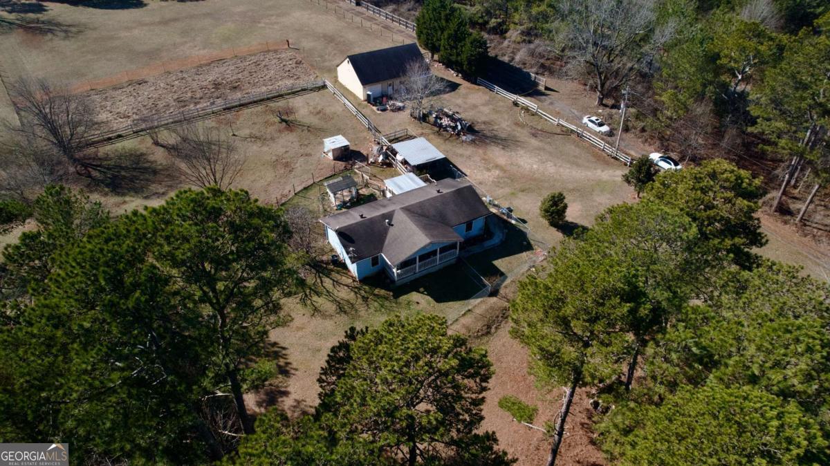 Welcome to this charming ranch home set on a generous 3.4-acre lot in the up-and-coming Dacula area! Enjoy privacy from all sides with plenty of open land-perfect for owning animals, farming, or simply spreading out and enjoying the space. The main level offers 2 bedrooms that share an oversized bathroom with a separate tub and shower. A bright kitchen and dining area bring in tons of natural light, creating a warm and inviting feel. The unfinished basement provides room to grow, with space to add 2 additional bedrooms, a bathroom, and a family room. Out back, a 6-car garage/workshop gives you even more room for storage, hobbies, or workspace. Whether you're looking for a peaceful retreat, a mini farm, or a fresh start in a growing community, this property has so much potential. Conveniently located near Hwy 316 and downtown Dacula-don't miss this opportunity!