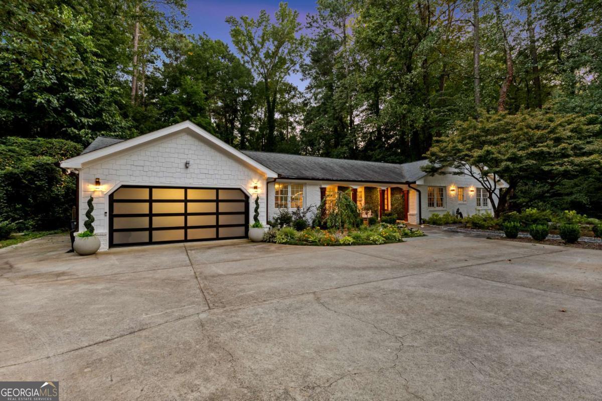 Newly renovated classic English ranch reimagined with modern luxury, this 4-bedroom, 2.5-bath home offers nearly 3,000 square feet of thoughtfully designed living space on a half-acre lot located 5 mins away from the Perimeter Mall. The oversized owner's suite features a cozy fireplace and a spa-inspired bath with elegant finishes, while the light-filled chef's kitchen showcases an oversized Cambria quartz island, premium appliances, and open flow for entertaining. With four spacious bedrooms and a dedicated office, the home strikes a balance between comfort and functionality, thanks to abundant natural light throughout. Outdoor living shines with a brand-new cedar pergola, white marble pavers, a tranquil Zen fountain, and a fully equipped outdoor kitchen complete with grill, refrigerator, and beer tap-perfect for gatherings. Both the front and backyard have been fully landscaped with upgraded plantings, highlighted by a mature Japanese maple tree and vibrant flowers designed to attract butterflies. Every detail of this renovation has been carefully curated to blend charm, elegance, and modern convenience. Move-in ready and waiting for its next chapter.