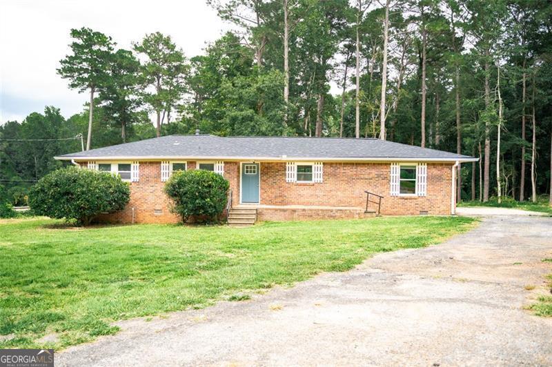 Welcome Home! This home features 3 beds/ 2 baths, 4 sided brick on a large 1.76 Acre private lot. MANY RENOVATIONS less than 4 years old include NEW HVAC system heat & air including NEW ductwork, NEW architectural roof, NEW gutters, NEW stainless appliances, NEW kitchen cabinets, NEW granite countertops, NEW flooring, NEW interior doors, baseboards and trim throughout, NEW lighting fixtures, NEW water heater, NEW tub/shower, vanity and toilet and FRESH paint, NEW plumbing and NEW windows! Conveniently located only 15 miles to Atlanta. Easy access to both 285 and 675. Large lot + recent removal of 30+ trees and grass seeds sewn. Create your own piece of paradise! Looking for a property where you could have your own little homestead? This could be your dream come true!