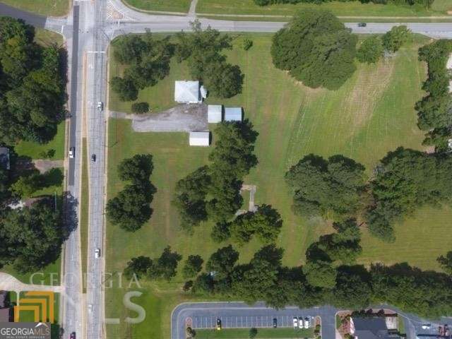 Awesome prime location property on the corner of Hwy 92 and Cowan Rd, across from Griffin First Assembly of God church! 7.1 acres, older 2 story 1904 built well maintained home, large out building, and several barns on the property.