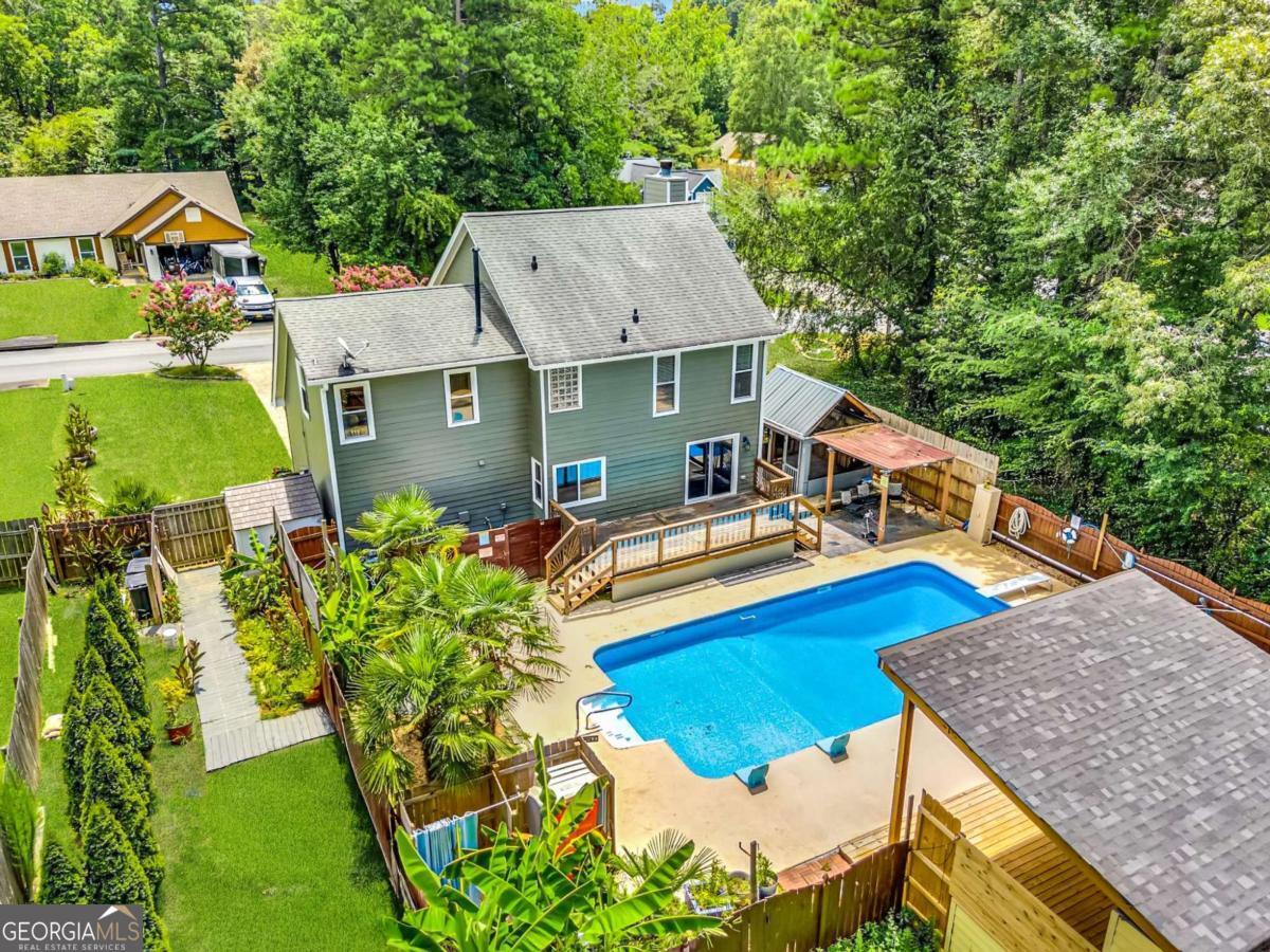 Welcome to your own private retreat! This charming 4-bedroom, 2.5-bath home sits on a serene half-acre lot in a quiet neighborhood with no HOA. Step into a cozy and inviting interior featuring hardwood floors, a spacious living and dining area, and a bright kitchen with granite countertops and white cabinetry. The true highlight lies outdoors-your private fenced backyard oasis awaits. Enjoy summers in the sparkling swimming pool, relax under the shaded gazebo, or entertain on the expansive decks. There's even an half bathroom for added convenience, plus a covered TV area perfect for game days or movie nights. The primary bedroom suite is a peaceful retreat with views of the pool, while the spacious secondary bedrooms offer plenty of room for family, guests, or a home office. This property combines comfort, privacy, and outdoor living at its best-all just minutes from local amenities. Don't miss the chance to make this one-of-a-kind property your next home!