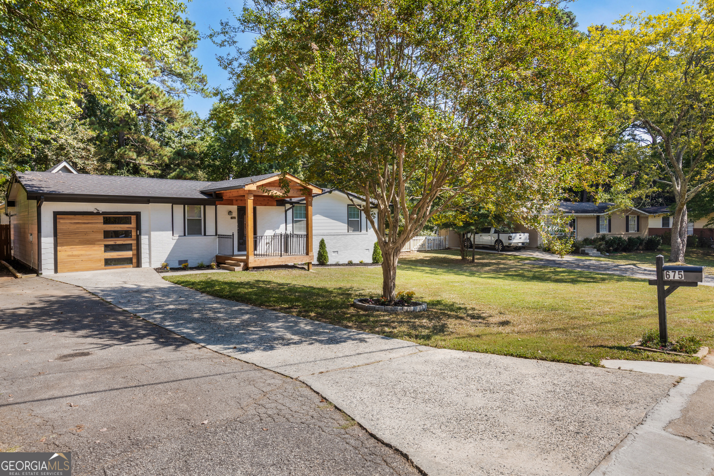 OPEN HOUSE SUNDAY 09/21 12-3PM! Stunning Mid-Century Modern Ranch Farmhouse in the heart of Smyrna, thoughtfully renovated with stylish upgrades and timeless charm. The chef's kitchen features custom real wood soft-close cabinets, quartz countertops, an oversized island (big enough for cooking and homework battles), pendant lighting, and stainless steel appliances. An open dining area with French doors flows seamlessly to the private fenced backyard-perfect for entertaining or escaping Zoom calls. Consistent luxury plank flooring, crown molding, and LED recessed lighting run throughout for a clean, modern look. Bathrooms are fully updated with quartz vanities, frameless glass showers, LED mirrors, and a double vanity in the hallway bath-because sharing a sink is overrated. Two primary suites include vaulted ceilings for added space and comfort. An expansive enclosed sunroom with wood-paneled ceiling, remote-controlled fans, and bar sink adds flexible living space-ideal as a gym, media room, or second family room. Major system updates include a new roof and HVAC (both under 3 years old) and new double-panel windows for energy efficiency. Tech perks include a Techo smart lock, EV charging outlet, and Chamberlain Wi-Fi myQ garage system-so yes, even your garage door is smarter than your ex. Exterior highlights feature fresh white brick with black trim, cedar porch detail with composite decking, level backyard, double driveway, and modern wood-and-glass garage door. This move-in ready home blends comfort, functionality, and character-ready for its next owner.