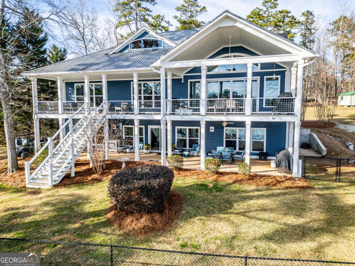 Lakefront Luxury in the Private & Serene East Lake Area!!! Escape to your own private retreat in the exclusive East Lake area, where breathtaking water views, peaceful surroundings, and modern comforts create the perfect lakeside escape. This stunning 4,200 sq. ft. home was built in 2018 to blend luxury and functionality, offering four bedrooms plus a spacious flex room, ideal for extra sleeping space, a private office, or a hobby room. Wake up to golden sunrises over the lake, spend your afternoons boating from your private double boat shelter and dock, and unwind on the covered deck, soaking in the quiet beauty of nature. The living area and chef's kitchen are designed for effortless entertaining, featuring soaring ceilings, panoramic view, gas cooktop, double ovens, a second sink, and oversized walk-in pantry. The terrace level is perfect for multi-generational living or a private guest suite, complete with its own full kitchen, living space, and private entry-offering comfort and independence for extended family, visitors, or long-term guests. Every detail was designed for comfort and convenience, from the whole-house generator to the custom-tiled showers with built-in seats and grab bars. A private elevator ensures step-free access, making every floor easily accessible. The separate powered workshop with a roll-up door offers endless possibilities for storage, projects, or lake gear. Nestled in a quiet, unrestricted community, this home offers seclusion without isolation, with an easy drive to shopping, dining, and recreation. Whether you seek a full-time lakefront haven or a weekend escape, this extraordinary property is ready to welcome you home. Schedule your private showing today!