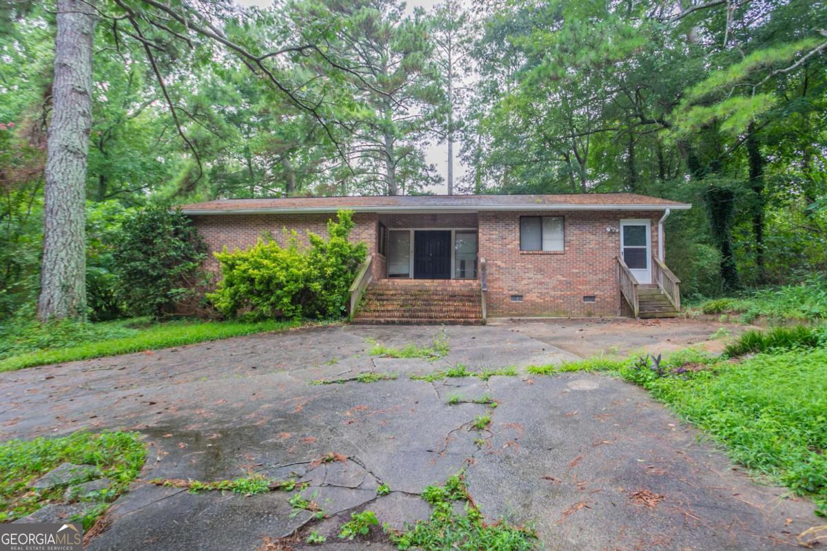 Solid 4-sided brick ranch tucked on a quiet street in Decatur with endless potential. This 3-bedroom, 2-bath layout offers a functional single-story floor plan, including a spacious living room and dedicated great room - ideal for hosting, relaxing, or reimagining to suit your vision. Nestled on nearly half an acre, the property provides ample outdoor space and a deck perfect for entertaining. With nearby access to I-285, I-20, and Downtown Atlanta, this location blends privacy with convenience. A smart pick for first-time buyers or investors looking for long-term upside.