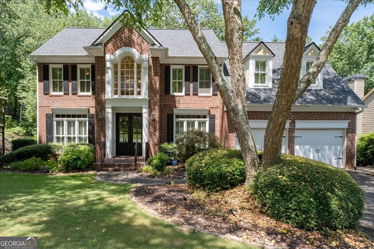Welcome to this beautifully updated traditional home located in a vibrant neighborhood with resort-style amenities including swim, tennis, and pickleball. With 5 bedrooms, 3.5 baths, and a fully finished basement, this home offers exceptional space, charm, and functionality. Step into a stunning two-story foyer that sets the tone for the home's elegance. The main level features a private office with French doors and custom built-in bookshelves, a formal living room, and a formal dining room perfect for entertaining. The completely remodeled kitchen is a showstopper with brand-new cabinetry, quartz countertops, a farmhouse sink, gas cooktop, and an extended island with an attached dining table. The kitchen flows seamlessly into the vaulted family room, where a stacked stone fireplace creates a warm centerpiece. A convenient half bath completes the main floor. Retreat to the spacious primary suite featuring an oversized closet, dual vanities, and a spa-like bath with a separate tub and shower. Three additional bedrooms and a full bath provide plenty of space for family or guests. The full finished basement offers incredible flexibility, complete with a bedroom, full bath, large living area, full kitchen, and ample storage perfect for multi-generational living, an in-law suite, or entertaining. The backyard is a private sanctuary with multiple levels to enjoy. Two decks overlook a beautifully landscaped yard, where a charming bridge and winding paths lead to a stone patio ideal for relaxing evenings or gathering around a fire pit. The level front yard adds to the home's curb appeal.Situated in an award-winning school district, this home combines everyday convenience with community lifestyle amenities.