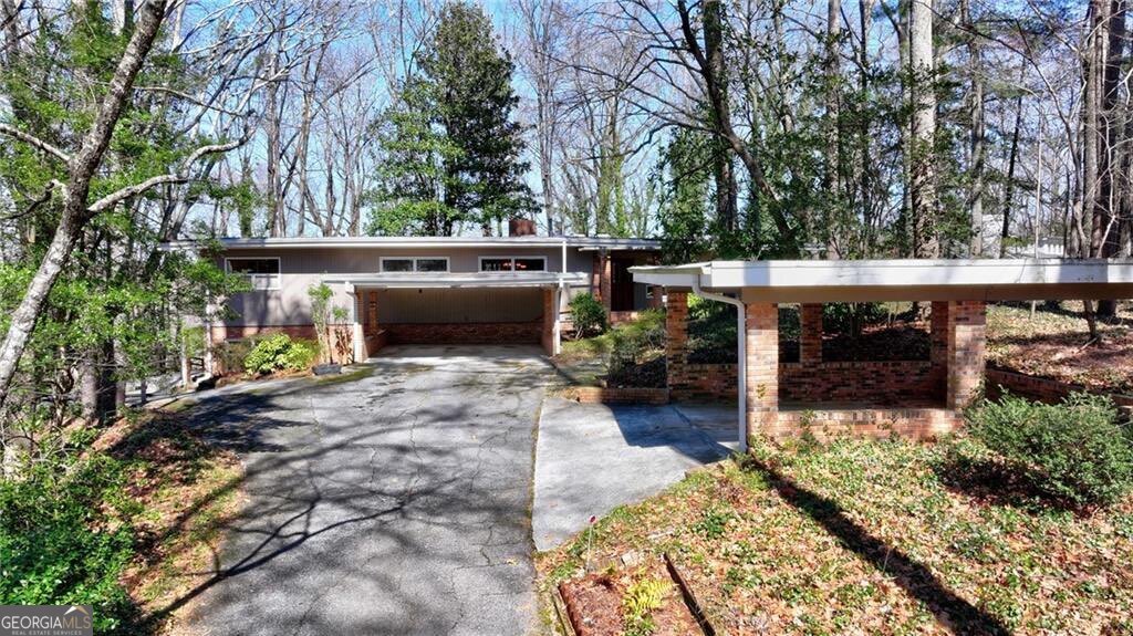 An opportunity exists to either remodel or rebuild a home on a 0.98-acre lot in Sandy Springs. The current home includes two bedrooms and three full baths on the main floor, plus a terrace level with a large rec room, bedroom, full bath, and office, and plenty of storage. The existing mid-century-style home, with its brick and wood exterior and large windows, is a perfect candidate for a deep, modern remodel. Seize a rare opportunity to craft your vision on nearly one acre of lush, private land in one of Sandy Springs' most sought-after locations. The potential for this property is limited only by your imagination, with options to either completely transform the existing residence or build a custom home from the ground up.