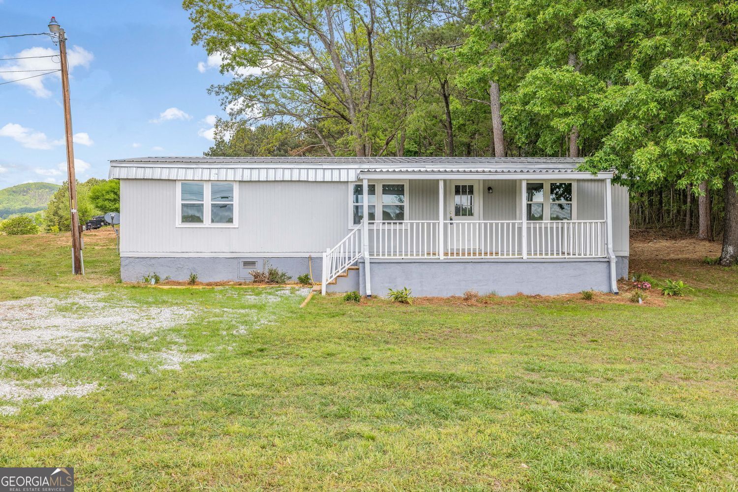 Discover the potential of this stunning lot in the highly sought-after North Hall area, with an approximate 1,100 square feet, three-bedroom, two-bathroom double-wide mobile home that has just been completely renovated and the property landscaped, cleared and cleaned up! Beautiful views from your front porch and mountain views from the back porch! Plenty of room for a large garden, animals, or whatever you may desire on the back side of the property, as there is no HOA or restrictions. Whether you're looking to invest or create your dream living space, this property offers unmatched value. Prime North Hall location, that's known for its serene environment and growing community. Expansive and versatile, providing ample space for further development or outdoor activities. With the double wide on-site, this property offers immediate living or rental income potential. The mobile home on the property is sold AS-IS, but has been completely renovated with beautiful finishes making it an amazing home or rental property. Brand new HVAC also installed in 2025! Upgraded plumbing, flooring, decks, gutters, and tons of other upgrades! The large lot also gives additional room on the back side of the property to potentially build in the future, if so desired (Buyer to complete their own due diligence with Hall County). The land and space offers plenty of parking for tractor trailers, transfer trucks, your boat(s) or whatever you may need or desire, as there's no restrictions! This property presents a unique opportunity in a high-demand area. All essential utilities are readily available, with water, power, and septic. All ensuring a smooth move-in process. Only approximately 5 minutes from the interstate, 10 minutes from Lake Lanier, and just outside the beautiful town of Clermont! Whether you're an investor seeking rental opportunities or a homeowner looking for living space with room to expand, this property is a must-see. Don't miss out on the chance to secure prime real estate in North Hall!