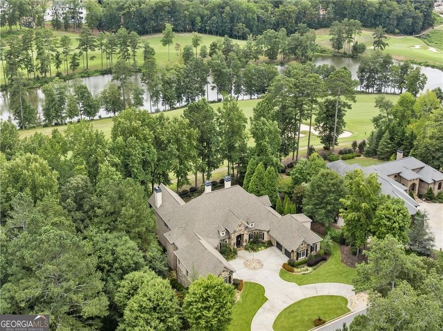 Experience exceptional resort-style living at 285 Traditions Drive, perfectly positioned on one of the most desirable LAKE AND GOLF COURSE lots in gated Echelon. From sunrise over Bryon Lake to sunset by the pool and spa, every moment here captures the essence of Milton/Alpharetta living-with the advantage of Cherokee County taxes. This all-brick and stone RANCH offers over 9,000 square feet of thoughtfully designed and fully updated living space + an additional 1,229 square feet of storage space, featuring MAIN-LEVEL LIVING, a finished terrace level, and ELEVATOR READY design. Panoramic lake views fill the home with natural light and tranquility, while the 4-car garage and additional storage make it a true car enthusiast's dream. The chef's kitchen showcases exposed beams, custom island, Wolf and Sub-Zero appliances, quartz surfaces, dual dishwashers, and walk-in pantry. Casual dining in the wonderful breakfast area with exquisite water feature and it's own wet bar with ice maker and custom cabinetry. The fireside keeping room and breakfast area open to a vaulted covered porch and outdoor dining terrace overlooking golf and lake front views. The primary suite includes a sitting area, coffee bar, fireplace, spa bath, and dual custom closets. The finished terrace level is an entertainer's dream: fireside family room, billiards area, full kitchen with dining, and a spectacular sommelier's tasting lounge for wine and whiskey gatherings. Two additional bedrooms, a half bath, laundry, and dual, his & her, poolside tiled baths + incredible storage space, complete this level.  Outdoors, a true resort oasis awaits with lush landscaping, stone pathways, saltwater pool and spa, covered and open-air patios, and dramatic evening illumination. 5 fireplaces, 2 laundry rooms.  Don't miss the additional flex room above the right hand garage- a perfect home office or teen suite.  A rare opportunity to own one of Echelon's finest homes-combining timeless design, breathtaking views, and exceptional amenities. Echelon offers a beautiful Rees Jones designed golf course and clubhouse- more than just a home, it's a lifestyle.  Impressive list of Updates and Upgrades(too many to list here-almost everything in this home is NEW) + Seller's Disclosures available upon request.