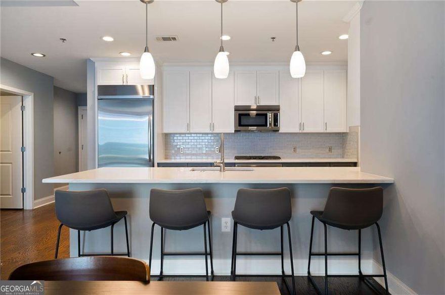 Soaring above the city skyline, this sophisticated residence at The Atlantic pairs dramatic floor-to-ceiling glass with timeless wide-plank hardwoods for a truly elevated living experience. This 2-bedroom, 2.5-bath home showcases sweeping city views and a spacious, light-filled layout ideal for refined urban living. The chef's kitchen features stainless steel appliances, gas cooking, and sleek finishes, while the sun-drenched primary bath offers double vanities, a separate soaking tub, a frameless glass shower, and abundant natural light. Enjoy seamless indoor-outdoor flow with generous balcony space perfect for entertaining or relaxing. Residents benefit from 24-hour concierge and security, a resort-style pool, state-of-the-art fitness center, and an elegantly designed club room-all in the vibrant heart of Atlantic Station.