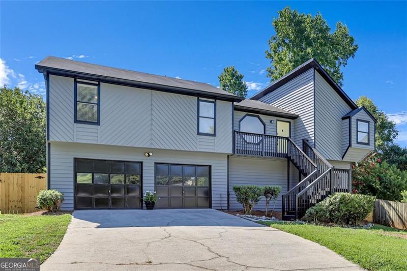 This wonderful 4 bed 3 full bath split-level home is move-in ready. It's just waiting for your special touches! Located in the well established non-HOA community of Quinn Ridge, just minutes from shopping, grocery, dining, entertainment and parks, including Stone Mountain and Yellow River. Very convenient to Scenic/Centerville Hwy (124) and Hwy 78. This freshly painted exterior and interior beauty has double balconies overlooking the private backyard as well as a front balcony where you can relish the remainder of the summer months in style. Inside you will enjoy your eat-in breakfast room & separate dining room both beaming with sunlight just off the large kitchen featuring loads of counter space with backsplash, tons of cabinet space, ss appliances, and beautiful tiled floors. The family room has a vaulted ceiling, hardwood flooring and is equipped with a stone fireplace to cozy up for the cooler months. The expansive second living area downstairs includes an en-suite bathroom with a brand new shower and personal walk-out to the backyard deck. This area is sure to give even more comfortability no matter how large or small your family is. The extra large garage equipped with working space & shelving completes this great home. Call for your private tour to see this home today!