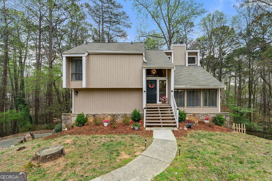 This stunning home has been completely renovated from top to bottom and is move-in ready! Your new home features 4 bedrooms, 2.5 bathrooms. Master is on main level, upper level has 2 bedrooms and a full bathroom plus 1 additional bedroom on basement level. Main level deck encompasses the entire length of the home with access options from dining room, kitchen and master bedroom. Enjoy the natural lighting from the generous windows in the living room, complete with fireplace for cozy nights. The kitchen boasts new granite countertops, offering ample counterspace, new backsplash, new refrigerator, new dishwasher, updated cabinet hardware, new kitchen faucet and a breakfast bar, making cooking and entertaining a delight. Spacious master bedroom, access to back deck, en-suite master bath with walk in tile shower, granite countertops, dual sinks, new lighting, new faucets, new mirror and large walk in closet. Upstairs features another living room, with a 2nd fireplace, wet bar, access to private deck and even better views, along with 2 secondary bedrooms and a full, newly updated bathroom. Basement level has an oversized 2 car garage on one side and a finished bonus room/bedroom, which can be used for home office, guest room, teen space, etc with patio access. New LVP throughout, new electrical panel, roof new June 2021, new water heater, new garage door opener, freshly painted inside and out, basement has been waterproofed, and much more, totaling over $150k of rehab, upgrades & improvements. Check this home out & see it's magnificence for yourself! To top it off, this fantastic home is located in the award winning trifecta of amazing schools, Mt Bethel, Dickerson and Walton as well as is incredibly close to the Chattahoochee National Park, Gold Branch hiking trails, and Roswell Boardwalk, shops at The Avenues of East Cobb, minutes to Publix, Kroger, Lidl, Target, Trader Joes, Sprouts, Whole Foods, Home Depot, Starbucks, Chick-fil-A, etc. Active swim/tennis community with playground, basketball courts and lots of social functions for all to enjoy!