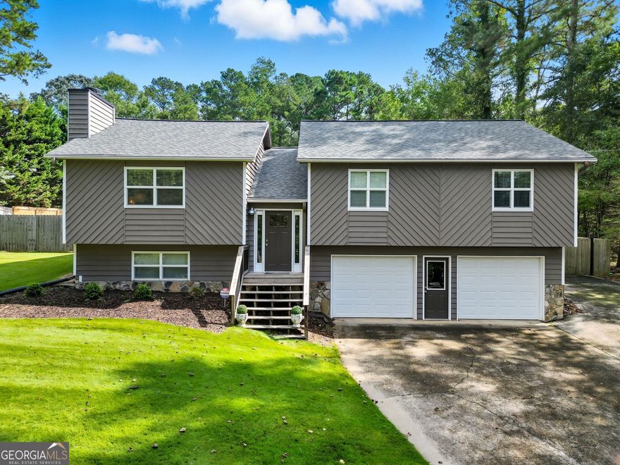 Welcome to this beautifully maintained and thoughtfully updated split-level home, nestled on a spacious one-acre lot just minutes from Lake Allatoona. Backing to private woods and fully fenced, the backyard is a true oasis featuring a stunning new pool perfect for entertaining or relaxing in total privacy. Inside, the modern kitchen boasts sleek new countertops and a stylish tile backsplash, and opens seamlessly to a large dining room and cozy living room with a stone fireplace and brandnew built-in bookcases. Rich hardwood floors run throughout the home, adding warmth and elegance. The oversized dining area is perfect for hosting gatherings and flows effortlessly into the kitchen and living spaces. A double car garage and unfinished basement offer plenty of storage or the opportunity to finish for even more living space. Whether you're throwing summer pool parties or enjoying quiet nights in, this home is the perfect blend of comfort, style, and functionality.