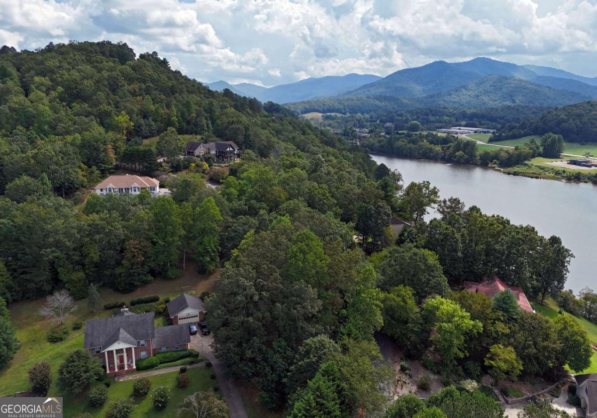 ASSUMABLE 2.37% Loan! Come live your Mountain and Lake Dream Life! Lovely 4 bedroom/3 bath home on one acre with 2 car garage. This home has room for the whole family and more! Surrounded by beautiful Lake Chatuge, the Blue Ridge Mountains and countless hiking options and waterfalls, this home is the perfect location for vacationing OR full time living! Main level has three bedrooms, two full baths, laundry, living room, eat in kitchen and separate dining room with Coffered Ceilings. Terrace Level boasts a large living space/flex area, another bedroom, full bath, lots of extra storage space/office space, a screened in porch and wonderful Pine wood Sauna and shower room. Home has recently be remodeled with new hickory floors. New appliances, countertops and back splash in kitchen. Master has new bathroom with walk-in shower, heated floors, fixtures, and vanity. New washer and dryer. New carpet in several areas, new water heater, and newer roof. LOTS of flexible space! Just 5 minutes to downtown shopping, schools and Lake Chatuge access. Fantastic, convenient location, but quiet and private. Home has synthetic stucco. Furnishings are negotiable.