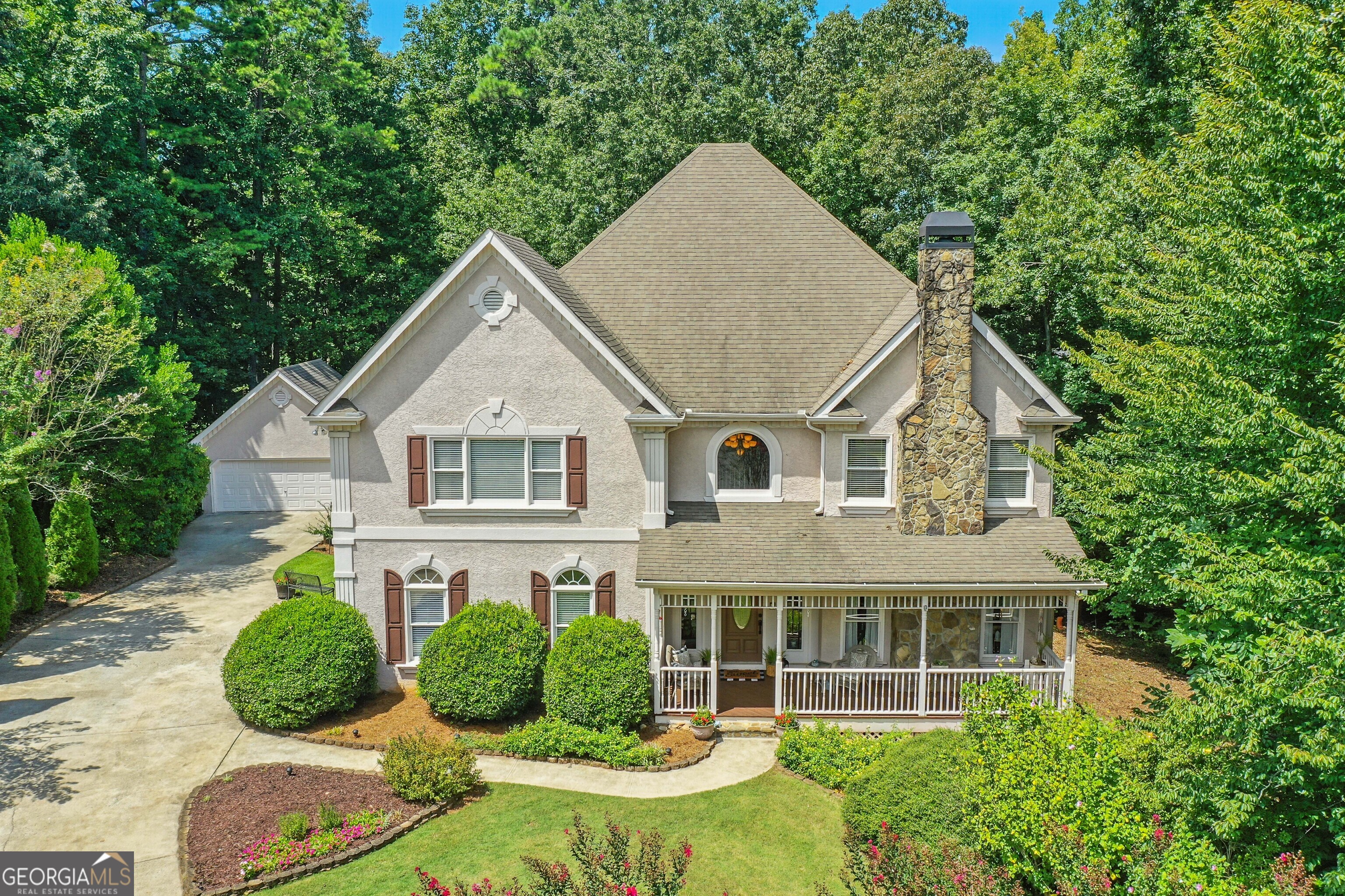 Nestled on a quiet, landscaped, cul-de-sac lot in the prestigious Lake Sovereign community, this spacious 5-bedroom, 4.5-bathroom executive estate is calling you home. Relax on the welcoming front porch before stepping inside and falling in love with the rich hardwood floors, high ceilings, arched doorways, and crown molding. The lofty 2-story foyer is flanked by a light and bright formal living room with a pretty bay window and cozy white fireplace. The separate dining room flows into the huge, cheerful, eat-in kitchen with hardwood floors, white cabinets, brushed nickel hardware, plenty of storage, a stainless-steel refrigerator and dishwasher, double ovens, separate gas cooktop, built-in desk, breakfast bar, and large eating area with vaulted ceilings and a view to the wooded backyard. Just off the kitchen is a relaxing family room with built-in bookcases, a stacked stone fireplace, a wall of windows and access to the large back deck that's perfect for enjoying your morning coffee, grilling out with friends, or simply unwinding at the end of the day. Retreat upstairs to the oversized master suite that boasts a double tray ceiling, crown molding, plenty of room for a sitting area, a double vanity, romantic fireplace, relaxing whirlpool bath, separate shower, beautiful stained-glass window, and large walk-in closet. An adjacent bedroom features an ensuite bath while two other spacious bedrooms share a Jack and Jill bathroom. There's plenty of room for work and for fun in the finished daylight basement that features a huge workroom (a woodworker or crafter's dream), a private office, and an additional family room with built-in bookcases and a gorgeous fireplace as well as a wet bar and full bathroom. Adjacent to the full bath is a big, bright and cheerful room that could easily be an amazing bedroom with its tray ceiling, crown molding, windows galore, and the perfect spot for a closet. The terrace level also boasts a large, three-season, glass enclosed patio. The additional, detached 2-car garage offers space for additional vehicles, a fishing boat and kayaks (perfect for use in the private, non-motorized lake), a workshop, or extra storage. The highly desirable Lake Sovereign community offers resort-like amenities including a private 38-acre stocked lake, a community dock, scenic walking trails, a neighborhood clubhouse, lakeside pool, fenced playground, and tennis/pickle ball courts. Located minutes away from top-rated schools, Blankets Creek Mountain Biking Trails, Northside Hospital Cherokee, the Cherokee County Aquatic Center, the Outlet Shoppes of Atlanta, the vibrant downtown areas in Woodstock and Canton, countless shopping and dining options, and quick access to I-575 and the Georgia Express lane, this home allows you to feel miles away from everything and yet remain conveniently close to all you could want or need!