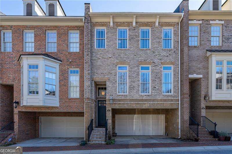 This elegant three-story brick townhome is ideally situated in Decatur, steps to Glenlake Park and the energetic Decatur Square. Enjoy the warmth of a freshly painted interior from the moment you arrive. The residence features three bedrooms and three and a half bathrooms, with hardwood floors and detailed moldings throughout the main living areas, and tile flooring on the terrace level. On the main level, you'll find a versatile living room that can serve as an office or playroom, a separate dining room, a powder room, and two closets for additional storage. The open kitchen, boasts a spacious island, high-end Viking appliances-including a six-burner gas cooktop, oven, and microwave-a Bosch dishwasher, ample cabinetry with custom pull-out drawers, granite countertops, and a walk-in pantry. An adjacent eat-in area overlooks the family room, which includes built-in shelving, a coffered ceiling, and a gas fireplace. A private deck extends from this space, providing a tranquil outdoor retreat. The upper level hosts a generous primary suite, complete with a bathroom that offers a separate tub, a glass walk-in shower with a tiled bench, and a double vanity with granite countertops. A dedicated laundry room equipped with cabinets and an additional closet is conveniently located in the hallway. The secondary bedroom suite on this floor is spacious, featuring a large walk-in closet and an updated bathroom with a granite vanity. The terrace level adds flexibility to the home, presenting a third bedroom with a full ensuite bathroom and access to a walk-out patio-ideal for guests or as a home office or den. The garage includes a substantial storage closet and opens into a mudroom on the terrace level, outfitted with custom cabinets for great storage. This townhome has been thoughtfully upgraded and offers abundant storage throughout. Its prime location allows for easy walks to a variety of restaurants and shops in Downtown Decatur and provides close proximity to the CDC, Emory University, downtown Atlanta, and more.