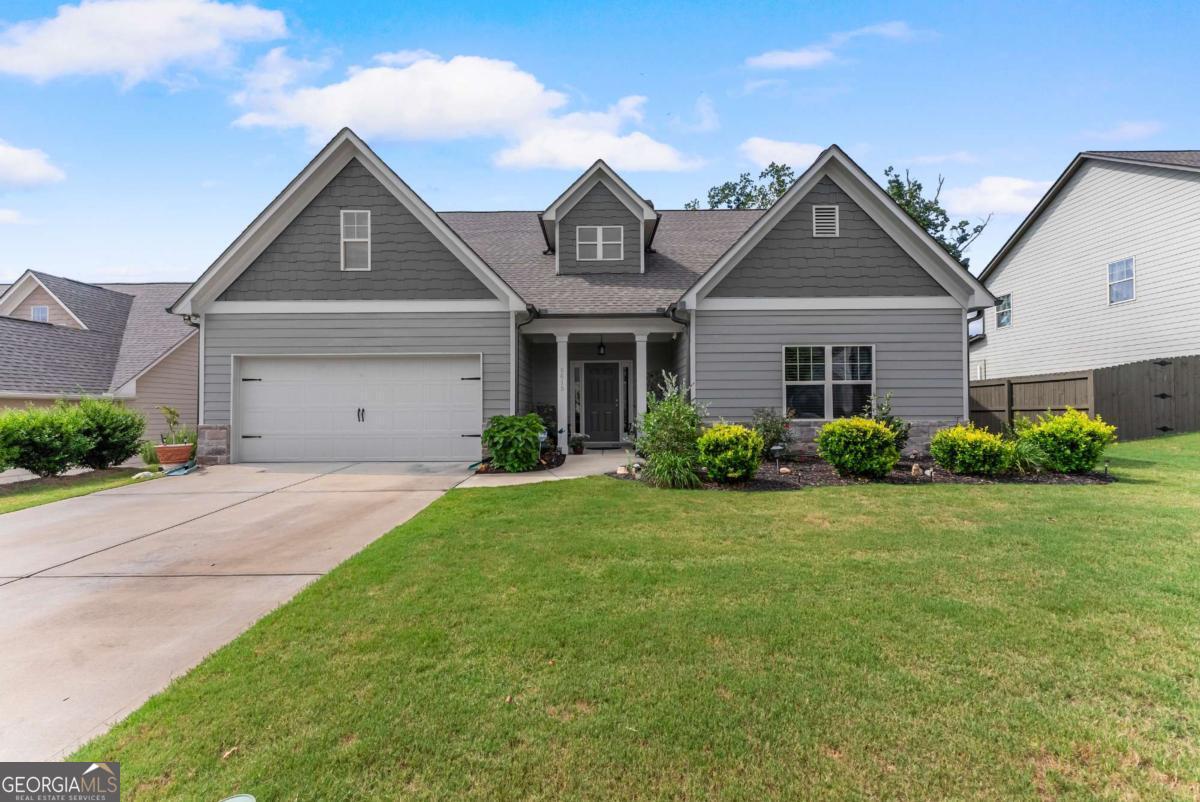 Spacious 4-Bedroom Ranch Near Lake Lanier with Upstairs Guest Suite! Welcome to this beautifully maintained 4-bedroom, 3-bathroom ranch located just minutes from Lake Lanier, shopping, and dining. Featuring an open-concept floor plan and hardwood & tile flooring throughout, this home seamlessly blends comfort and style. The spacious kitchen is a chef's dream with stainless steel appliances, solid surface countertops, crisp white cabinetry, and a large island overlooking the dining area and fireside family room-perfect for everyday living and entertaining. The oversized primary suite on the main level boasts a tray ceiling, walk-in closet, and a spa-like en suite with tile finishes, double vanities, a soaking tub, and a separate shower. Upstairs, you'll find a private guest suite with its own bedroom and full bath-ideal for visitors, teens, or a home office. Enjoy the professionally landscaped, level backyard from the covered back patio complete with a ceiling fan. The fenced yard offers privacy and plenty of space for outdoor entertaining. A 2-car garage completes this move-in ready home. Don't miss your chance to own this stunning property in a sought-after location!