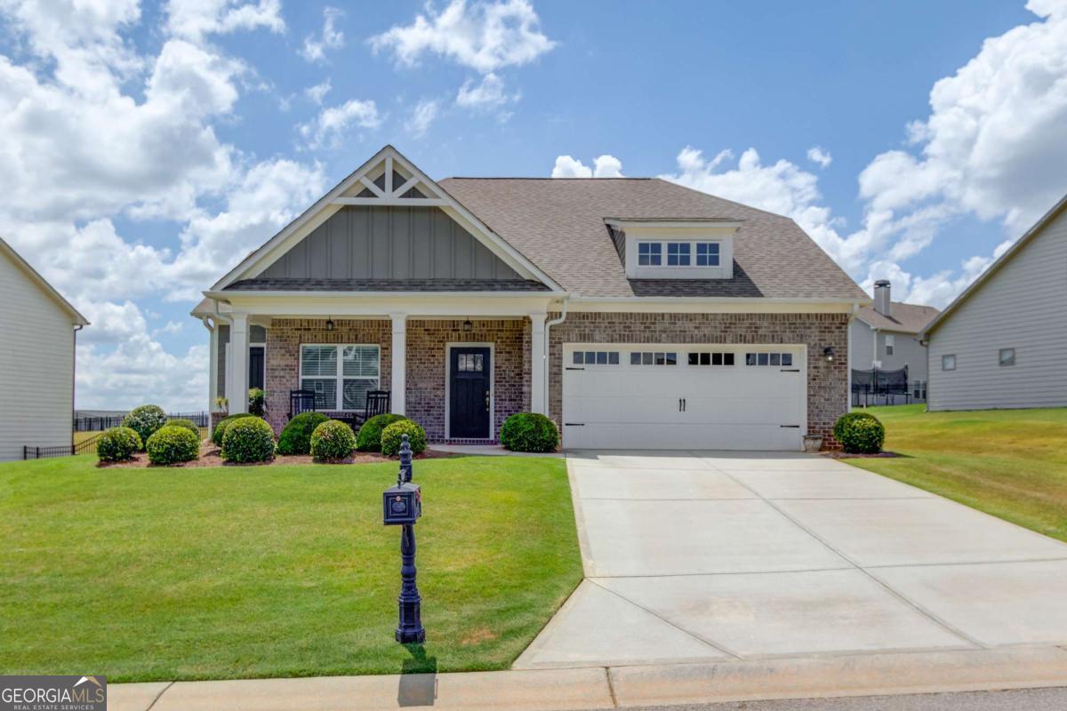 Located in the highly sought-after Traditions of Braselton, this beautifully maintained ranch-style home offers a blend of comfort, accessibility, and resort-style living. Built in 2019, the home features an open floor plan, engineered hardwood floors, and zero-step entry, ideal for ease of living.The spacious primary suite includes a separate tub and shower along with a large walk-in closet. Two additional bedrooms are on the main level, while the upstairs bonus room offers flexible living space plus a walk-in attic area with potential for future expansion. Enjoy a modern white kitchen with walk-in pantry, main-level laundry, and seamless flow into the living and dining areas. Outside, the rocking chair front porch and covered back patio overlook a low-maintenance yard, perfect for relaxing or entertaining. This home is just minutes from Publix, shopping, dining, and offers easy access to I-85. Residents enjoy exceptional resort-like amenities including a golf course, clubhouse, on-site restaurant "Twenty-Seven," tennis and pickleball courts, Olympic-sized pool with water slide, playground, and miles of sidewalks for walking. With endless opportunities for socializing, club meetings, and community events, it's the perfect option for those who want an active, social lifestyle-without the commitment of a 55+ community and with a variety of age groups. Come see what makes this home and community truly special-schedule your showing today!