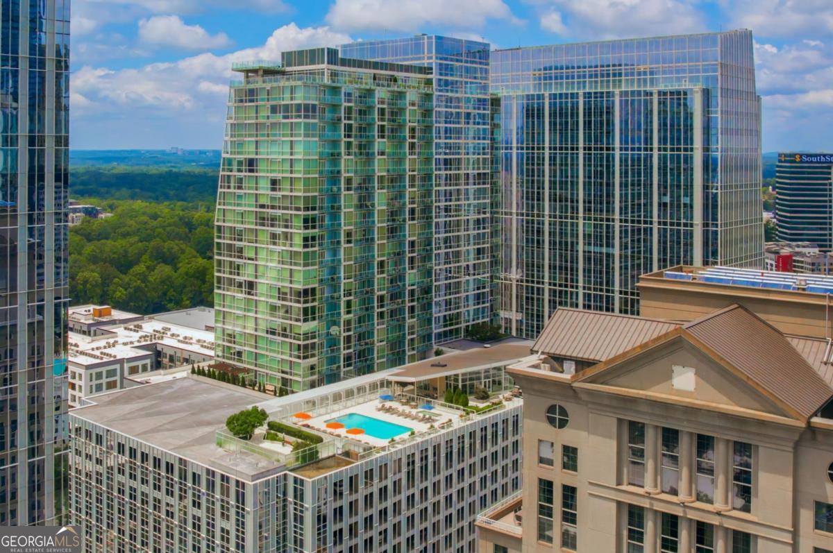 High above the city on the 18th floor of the prestigious Terminus building, this stunning 2-bedroom, 2-bath corner residence epitomizes elevated Buckhead living-with sweeping, unobstructed views from Truist Park to the glittering Downtown Atlanta skyline. Wrapped in floor-to-ceiling glass, the space is bathed in natural light by day and sparkles with city lights at night. Inside, refined finishes and a thoughtfully designed layout offer the perfect blend of elegance and everyday comfort. The chef's kitchen features premium Sub-Zero and Wolf appliances, granite countertops, custom cabinetry, and a gas cooktop-ideal for entertaining or casual cooking. The open-concept floor plan invites flexibility, easily accommodating a home office, dining area, or cozy media lounge-all surrounded by panoramic cityscapes. The primary suite is a tranquil haven with dual walk-in closets and a spa-inspired bath. A spacious secondary bedroom includes an en-suite bath and oversized closets for ample storage. Additional highlights include a dedicated laundry closet (washer/dryer included), tankless water heater, and two secure parking spaces. Enjoy five-star amenities at Terminus: a saltwater pool and hot tub, landscaped terrace, state-of-the-art fitness center, massage room, clubroom, game lounge, guest suite, and a private pet walk. Full-service living includes 24-hour concierge, valet, and onsite security. Located in the heart of Buckhead's vibrant corridor, you're just steps from upscale dining, shopping, and nightlife with easy access to MARTA and major highways. This isn't just a home-it's a lifestyle. Welcome to life above it all at Terminus.