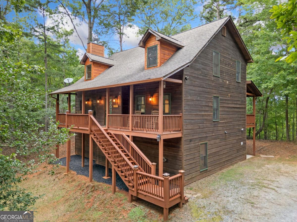 This is not your average mountain home. Tucked inside the gated community of Coosawattee River Resort, this property offers the rare combination of function, charm, and income potential - all set on a wooded lot with mountain views, resort amenities, and deer at your doorstep. Spanning approximately 3,000+ sqft, this 3-story above ground home has 5 bedrooms, 3.5 baths, and multiple outdoor living spaces including a wraparound front porch, three balconies, and a private hot tub/sauna off the main deck. Interior Highlights alone include: Lower level features a gaming area, bar, pool table, two bedrooms, a full bath, family room, and projector-ready wall - ideal for movie nights or entertaining. Walk directly out to the yard where deer roam peacefully + frequently. Home has main level living complete with open-concept kitchen with ample counter space and walk in pantry. This is connected to a perfectly sized dining area + view to the family room which includes a newly updated wood-burning fireplace. With 5 bedrooms across all three levels, this home is perfect for everyone from families, guests, or rental flexibility. This home also is outdoor living at it's finest: The main deck includes an updated wood burning fireplace and a hot tub/sauna for true mountain relaxation. Upper-level balcony with a hammock and long-range mountain views - perfect for reading or stargazing. The Wraparound front porch is ideal for morning coffees or shaded afternoons. Backyard firepit is great for late nights or cooler evenings talking about the life events with family and friends. As an Investment Opportunity, this home can be sold fully furnished and is eligible for short-term rentals (Airbnb/VRBO) under Coosawattee River Resort's active rental program. With Ellijay consistently ranked among the top 10 vacation rental markets in the U.S. (Forbes), this property offers strong income-producing potential as a vacation rental or second home. Here are some of the Community Perks of Coosawattee River Resort: 3 pools (one indoor), fitness center, game room - River access with kayaking, canoeing, and fishing at Beaver Lake and Canoe Park - Tennis and pickleball courts, 18-hole mini golf, hiking trails - Multiple RV/tent campgrounds including Ogden RV Park - Secure 24/7 gated access - And you can't beat the location. Just minutes from the dining, wineries, shopping, and festivals of Downtown Ellijay, while still enjoying the peace and privacy of a wooded mountain enclave. Welcome home!