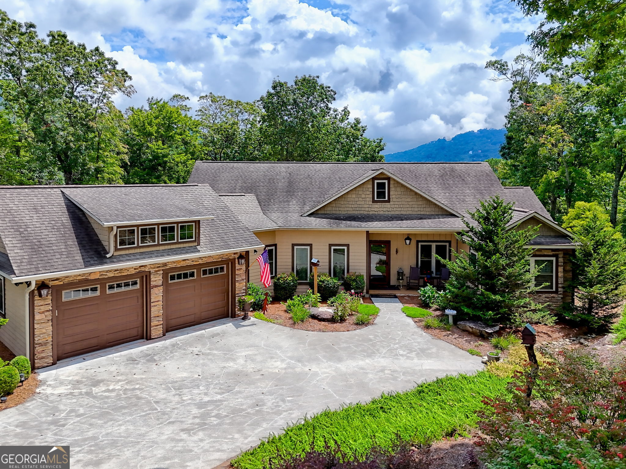 Welcome to one of Rabun County's best-kept secrets! This custom-built home (2012) offers 4,282 sq ft of beautifully designed living space on 1.11 acres, just minutes from downtown Clayton but outside city limits-so you'll enjoy the convenience of city water without city taxes and the freedom of no HOA. From the moment you arrive, the mountain views front and back and the beautifully landscaped setting make this property feel special. Step inside to discover a thoughtful floor plan with 4 bedrooms and 4 full baths. The main level features an inviting owner's suite with access to the all-seasons room, vaulted ceilings, hardwood floors, pine paneling, and a cozy fireplaces. The kitchen is the heart of the home with knotty alder custom cabinets, granite counters, and open flow-perfect for entertaining family and friends. A screened porch, office/loft space, and 2-car garage on the main level add to the comfort and functionality. The terrace level offers its own separate entrance and is ideal for extended living or guests. It includes a kitchenette, covered patio, fireplace, 2 bedrooms and 2 baths (one a private suite), a hobby room, shop, abundant storage, and even an unfinished safe room. With a whole-house generator, central vacuum system, dual-fuel zoned HVAC, and abundant porches and decks, this home is as practical as it is charming. Every detail has been well cared for, and it shows. If you're looking for craftsmanship, comfort, and mountain living with modern convenience-this is it.