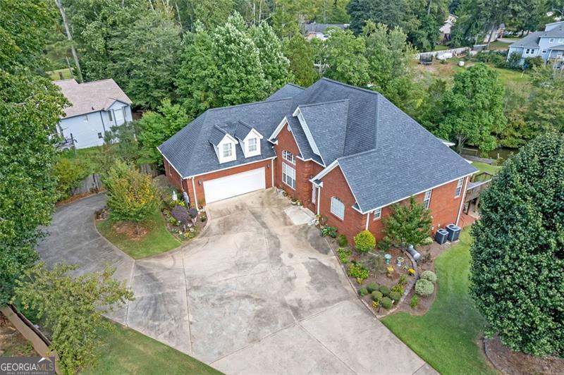 Embrace a lakefront lifestyle in this 5,723 square foot home featuring 7 bedrooms and 5.5 bathrooms in Conyers, on just over half an acre of manageable land. Wall-to-wall windows frame the serene lake views, creating a seamless connection between indoor comfort and waterfront lifestyle. Competitively priced to reflect authentic character details, including original wallpaper (a design element experiencing renewed popularity in contemporary design). The current owners have maintained this property with exceptional care and are seeking new owners who will appreciate this special lakefront sanctuary as they turn the pages to a new chapter of their lives. The low-fee Lakefront HOA only controls the lake rules and does not limit your property, meaning complete freedom to personalize your waterfront oasis. The generous floor plan supports a primary residence, vacation retreat, and or an investment opportunity. This gem delivers lake lifestyle in a quality-built home that just needs personal touches to make it uniquely yours.