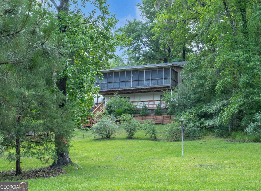 Rustic waterfront retreat with tranquil views on the Satilla River! This 4BR/2BA home sits on 1.83 Acres & features a custom dock complete with covered picnic area, floating dock, and boat lift. Main level has spacious living room, dining area, kitchen that boasts granite counters & stainless-steel appliances which includes refrigerator, stove & built-in microwave. Main level has 2 BRs & 1 BA. Conveniently walk out & relax on the upstairs screened porch & watch the sun set over the river. The lower level has a den/recreation area, laundry rm, 2 BRs & 2nd BA. The Evenings can be spent by the fire pit under the stars. This amazing 27' x 41' detached garage has plenty of room for utility storage & workshop. Roof only ONE YEAR old. No city taxes required! Seller is offering Buyers Old Republic Gold Home Warranty!