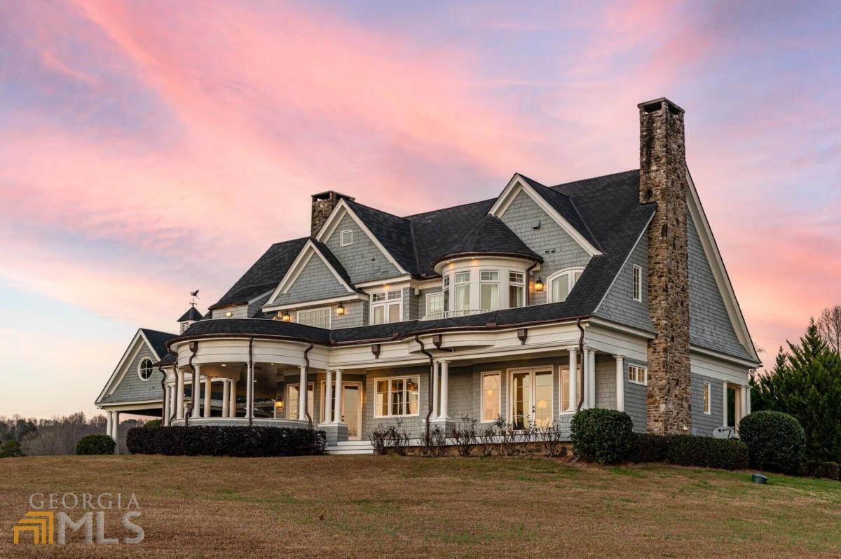 An oasis is waiting for you just off of GA-400 in Forsyth County. Surrounded by water on 3 sides, 7180 Lawson Drive is the perfect place to call home. The home was built in 2007 and is situated on 1.43 acres of land. Upon entering the front door, youCOre greeted with stunning hardwood floors that flow throughout the entire home. The great room is open concept and hosts a magnificent stone fire place. Turn around, and youCOre welcomed into the beautiful kitchen with high end stainless steel appliances, marble counter tops, and a large island. An En-suite is also located on the main level. A game room is perfectly located with French doors that open up to the hot tub and grand pavilion that has its own fireplace. Up the spiral staircase are the owners suite, two large bunk rooms, and two private En-suites. Ready to take advantage of that stunning lake? The slip party dock is just a short walk or golf cart drive and is fitted with six jet ski hoists and two boat hoists. This home was made for you to fully embrace lake life and the gorgeous Georgia sunsets with its covered patios and outdoor living areas. There is room to add in a pool, if desired. Take a break from busy city life and make this oasis your home, you wonCOt regret it