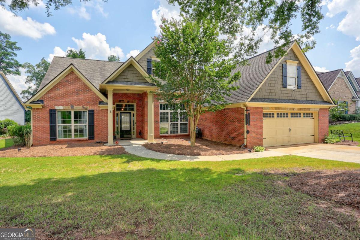 Welcome to this unbelievably spacious and updated ranch style home exuding charm and character. On arrival you are met with professional landscaping and a sophisticated facade punctuated by grand columns. Upon entry you are greeted by gleaming wood floors that extend throughout this carpet-free home. The open floor plan harmonizes modern design and classic details. Flanking the foyer is a large, versatile den or home office. Modern fixtures and soaring ceilings adorn the delightful formal dining area that adjoins the living area with double-sided fireplace. Entertaining and everyday meal preparations are made easy in the well-appointed kitchen with SS appliances and an abundance of beautiful cabinetry. The window lined breakfast nook and sunroom lend a picturesque view of the back yard. Split bedroom plan with two generously sized secondary bedrooms and a full bath on one side of the home, in addition to a half bath for guests. Prepare to be amazed by the enormous primary retreat with a dazzling spa like bathroom. Upstairs is a fourth bedroom and an updated full bathroom creating a functional space with endless possibilities. Step outside to discover a covered patio highlighting the wonderful backyard with new fence. Conveniently located near shopping, restaurants, Mall of Georgia, Hamilton Mill and both 85 and 316.