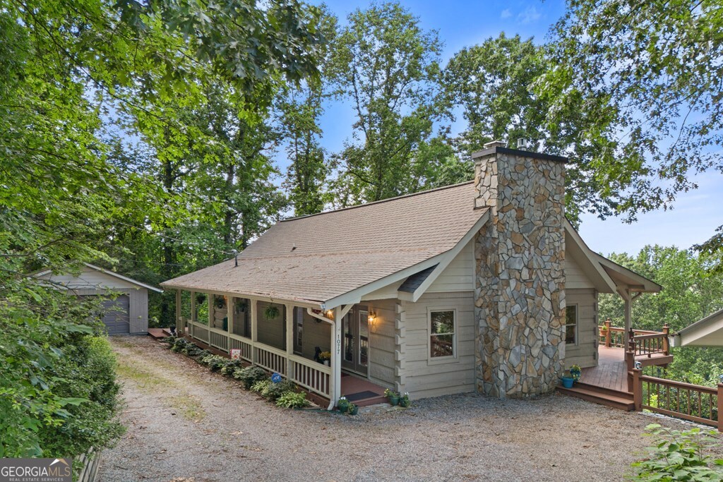 A NORTH GA CABIN WITH LAKE & MOUNTAIN VIEWS! This Lake View home features a huge wrap around porch for easy Lake Chatuge viewing. The leaves in the fall and the boats in the summer make this cozy log cabin perfect for coffee on the porch, a walk up the mountain, or blankets by one of the fireplaces. Master on Main with a large walk in shower, double sinks, and a custom built in closet is perfectly nestled in the middle of the cabin. Custom kitchen with Ambrosia wood cabinets, pantry, granite countertops, island and stainless steal appliances. Hardwood throughout the main floor, newer windows, lighting and sliding glass doors allow for 180 views of the mountains and lake. Downstairs has two extra bedrooms and a full walk in shower, huge storage options with shelving and viewing windows. Double car detached garage has a shop built in for all the tools. In 2011, the whole house was basically renovated including ceiling, windows, countertops in baths, hardwoods, carpets downstairs, tile, lighting, and cabinets.
