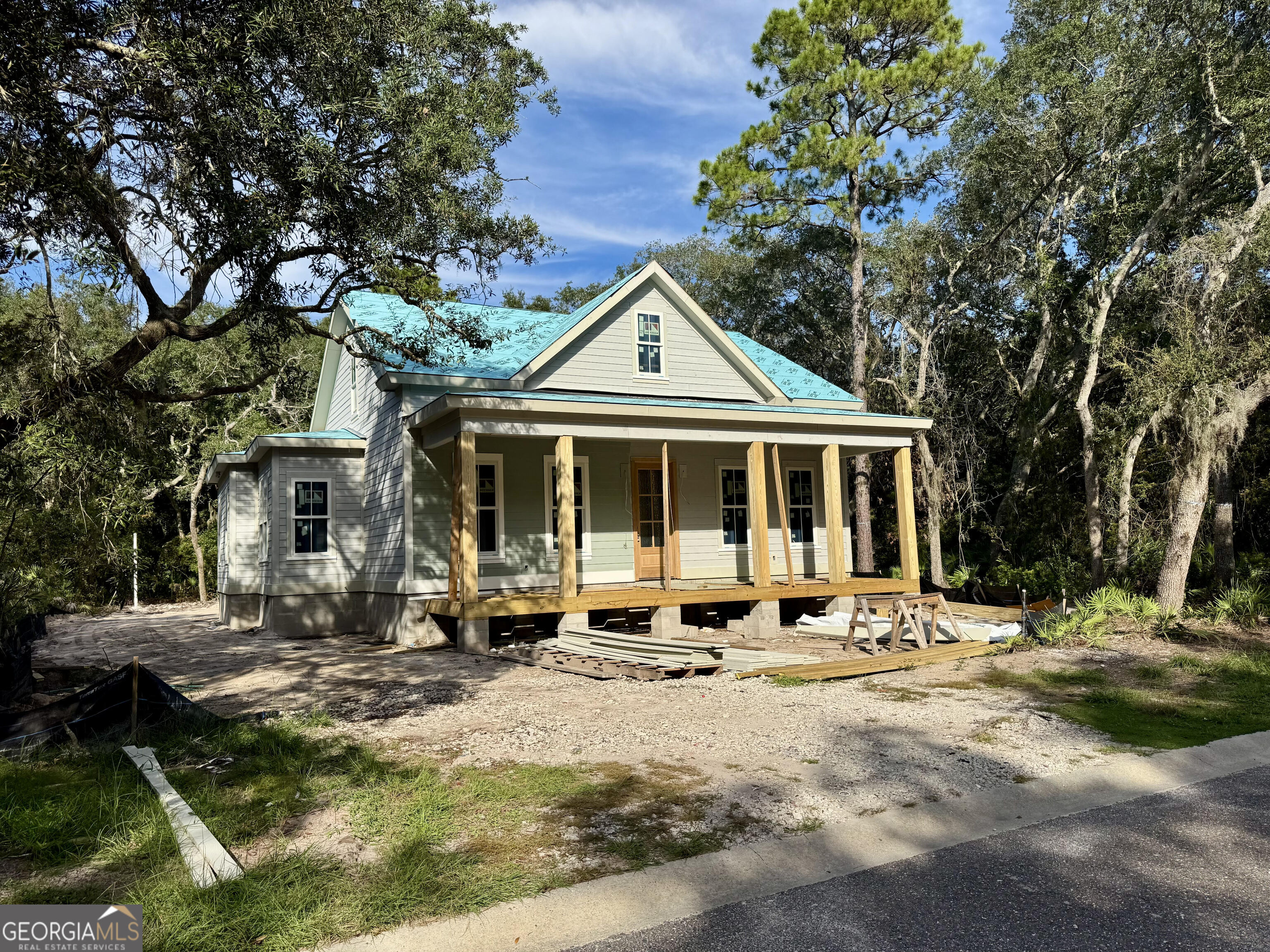 NESTLED BENEATH MATURE OAKS IN THE DAZZLING, GATED COMMUNITY OF CUMBERLAND HARBOUR, THIS UNDER-CONSTRUCTION THREE-BEDROOM HOME BLENDS TIMELESS LOWCOUNTRY CHARM WITH MODERN FEATURES. THE EXTERIOR SHOWCASES DURABLE HARDIE SIDING, A METAL ROOF, AND AN INVITING FRONT PORCH, PERFECT FOR YOUR ROCKING CHAIRS. A SPACIOUS SCREENED LANAI OVERLOOKS THE BACKYARD, WHILE THE OVERSIZED TWO-CAR GARAGE FEATURES A REAR ENTRANCE WITH DIRECT BACKYARD ACCESS AND A DRIVEWAY THAT OFFERS PLENTY OF PARKING. STEP INSIDE TO HARDWOOD FLOORS THAT FLOW THROUGHOUT THE LIVING AREAS. THE FAMILY ROOM IS ANCHORED BY A COZY GAS FIREPLACE, WHILE THE EXPANSIVE KITCHEN SHINES WITH AN OVERSIZED ISLAND WITH SEATING, A SPACIOUS BUTLER'S PANTRY, AND A PICTURESQUE FARM SINK FRAMED BY A LARGE WINDOW. THE DINING AREA IS FILLED WITH NATURAL LIGHT AND EASILY ACCOMMODATES A LARGER TABLE- IDEAL FOR HOSTING GATHERINGS. THE PRIMARY SUITE IS A TRUE RETREAT, BOASTING SEPARATE VANITIES, A PEDESTAL TUB, AND A LARGE TILED WALK-IN SHOWER, ALONG WITH ABUNDANT STORAGE. A WELL-APPOINTED LAUNDRY/MUD ROOM ADDS CONVENIENCE WITH EXTENSIVE CABINETRY AND A SOAKING SINK. ADDITIONAL FEATURES INCLUDE SPRAY FOAM ATTIC INSULATION, WOOD SHELVING THROUGHOUT, CROWN MOLDING, A GAS RANGE, GAS TANKLESS WATER HEATER, AND A GAS HOOKUP FOR OUTDOOR GRILLING. THE GARAGE IS FINISHED WITH T-111 WALLS AND THE HOME IS EQUIPPED WITH A PEX MANIFOLD SYSTEM FOR EFFICIENCY AND DURABILITY. CUMBERLAND HARBOUR HAS BEEN AWARDED IDEAL LIVING MAGAZINE'S TOP 100 COMMUNITIES TEN YEARS IN A ROW: RESIDENTS ENJOY 24/7 GUARDED ENTRY, THREE SWIMMING POOLS, SIX TENNIS COURTS, A CONFERENCE AND FITNESS CENTER, PLAYGROUND, FISHING SPOTS, AND BOAT/RV STORAGE. THE AMENITIES CENTER EVEN INCLUDES GOLF CART AND BICYCLE PARKING. FLOOD INSURANCE IS NOT REQUIRED, AND THIS DISTINCTIVE HOME IS EASY TO SHOW-PLEASE NOTE THAT ENTRY INTO CUMBERLAND HARBOUR REQUIRES ACCOMPANIMENT BY A LICENSED AGENT OR RESIDENT.