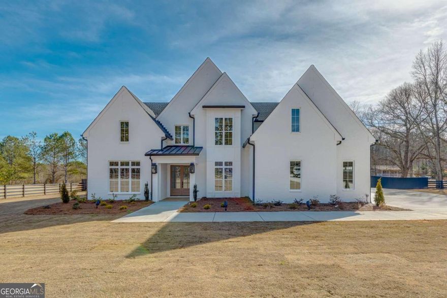 Welcome to this impeccably crafted custom home boasting upgrades throughout. This stunning residence features 5 bedrooms, 6 full baths, 2 half baths, along with a 4-car garage, perfectly suited for accommodating the entire family. Situated on 3.311 acres of private land , fenced-in backyard, this estate offers a pristine, level landscape. The highlight of the outdoor space is the heated saltwater oasis, complete with a custom pool, hot tub, and spa. Upon entering, you are greeted by a grand 2-story foyer leading to a custom-appointed office and a versatile flex-space, ideal for formal living or dining, complete with a bar area. Continuing through the home, you'll find a spacious great room featuring a coffered ceiling, a striking floor-to-ceiling fireplace, and custom cabinetry. The kitchen is a dream, boasting an oversized island, quartz counters, professional-grade stainless steel appliances, an oversized walk-in pantry. Tucked away in the back, you will find the prep kitchen which offers a secluded spot to prepare food and drinks, away from the hustle and bustle of open concept kitchen. The main level master suite is a luxurious retreat, offering a vaulted ceiling, ample natural light, and French doors leading to a spa-like bathroom. Upstairs, four individually appointed mini-master suites each feature their own bathroom and custom walk-in closet. Additionally, there's a second laundry room and a generously sized loft area with a fireplace and mini-kitchen, perfect for entertaining. For outdoor enjoyment, step outside from the gourmet kitchen to a covered patio with an outdoor kitchen, pellet smoker, prep counters, and open shelving. A custom fireplace adds ambiance to the outdoor space, which overlooks the private aquatic oasis enclosed by privacy fencing. Conveniently located just minutes away from the brand-new Harbins Road development, offering access to Publix, dining, shopping, and entertainment. This home is also a short drive from Downtown Dacula, Buford, Lawrenceville, and approximately 30 minutes from the University of Georgia and Athens area. Welcome home to luxury living at its finest!